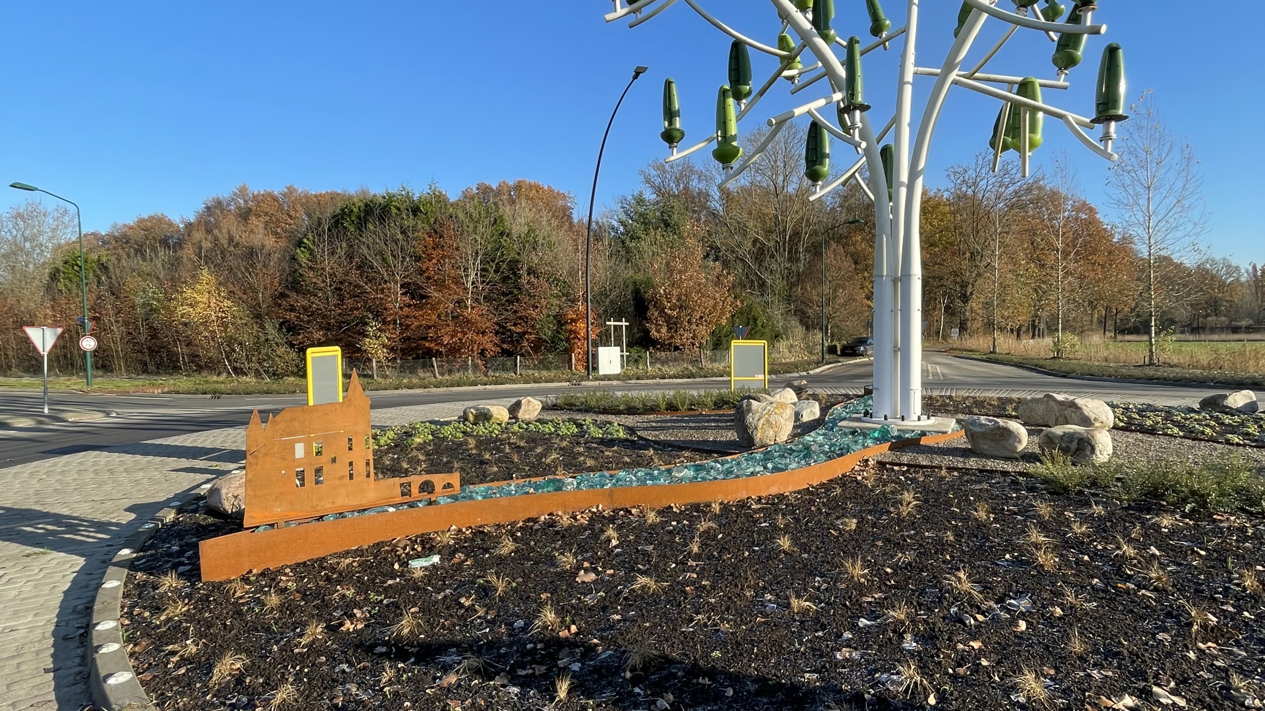 Uitsnede in metaal van kerk met de Windenergieboom op de achtergrond