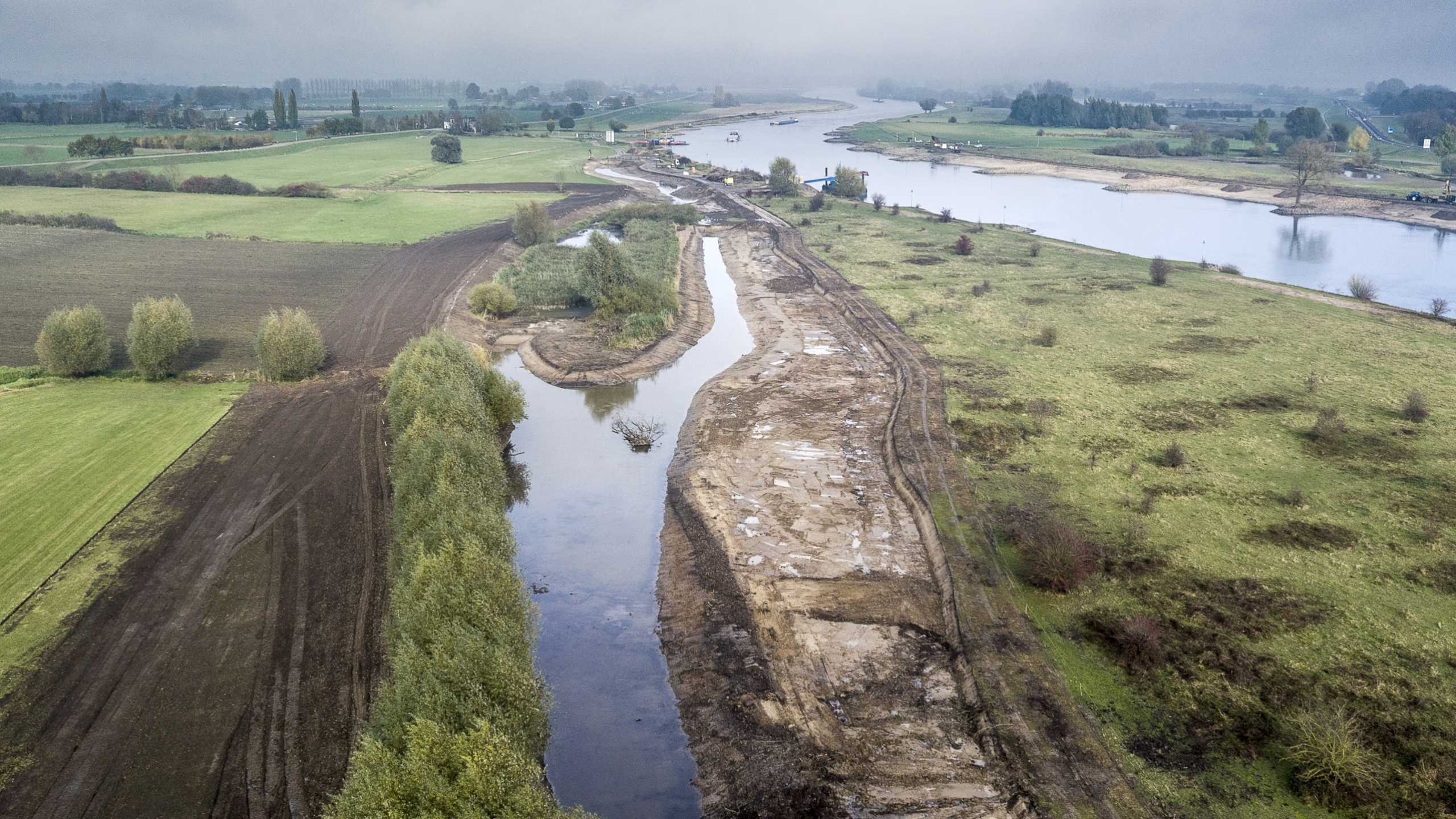 Luchtfoto van de IJssel met beekje stroomt door de groene weilanden