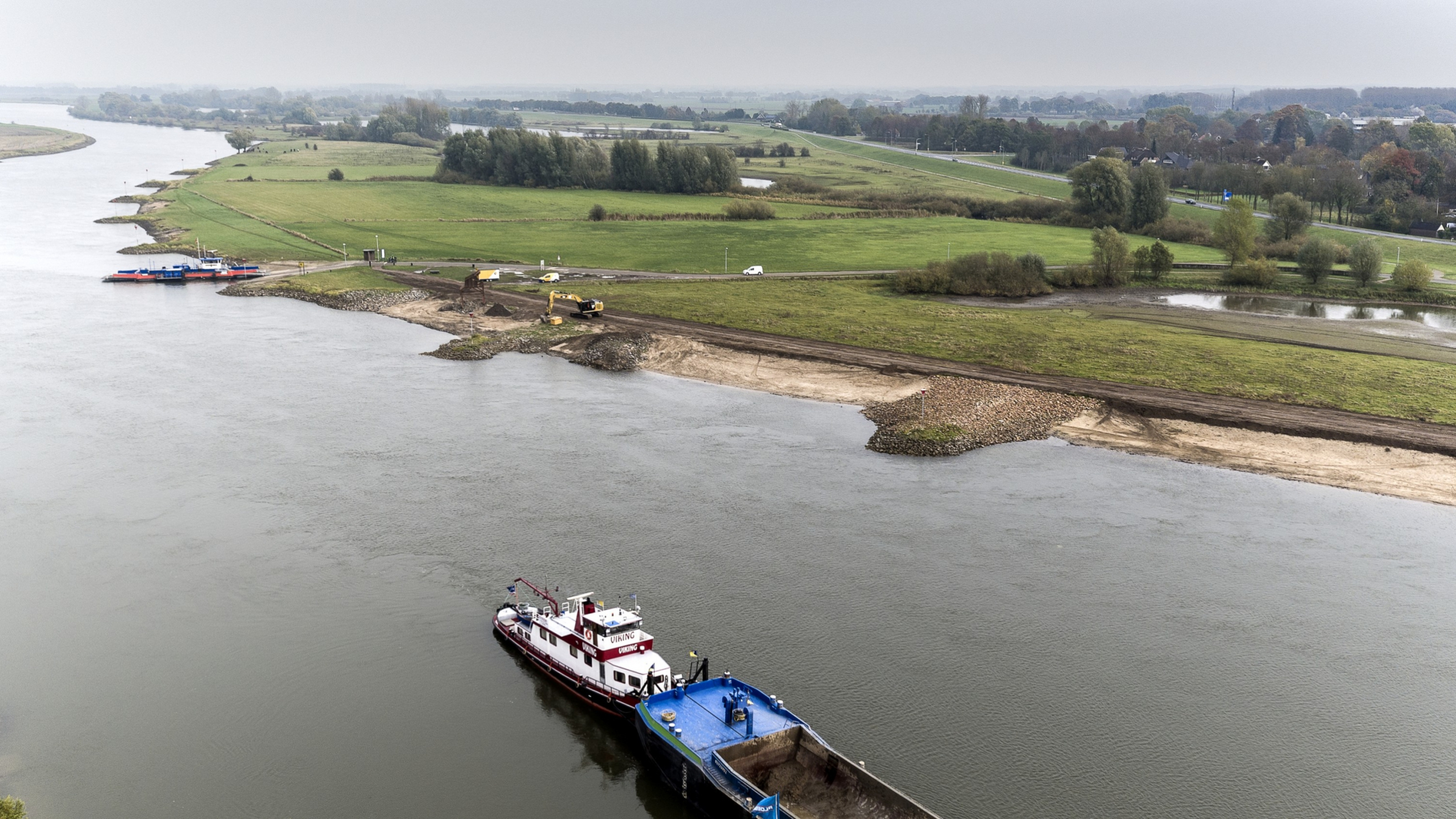 Luchtfoto van schip vaart over de IJssel met groene weilanden op de achtergrond