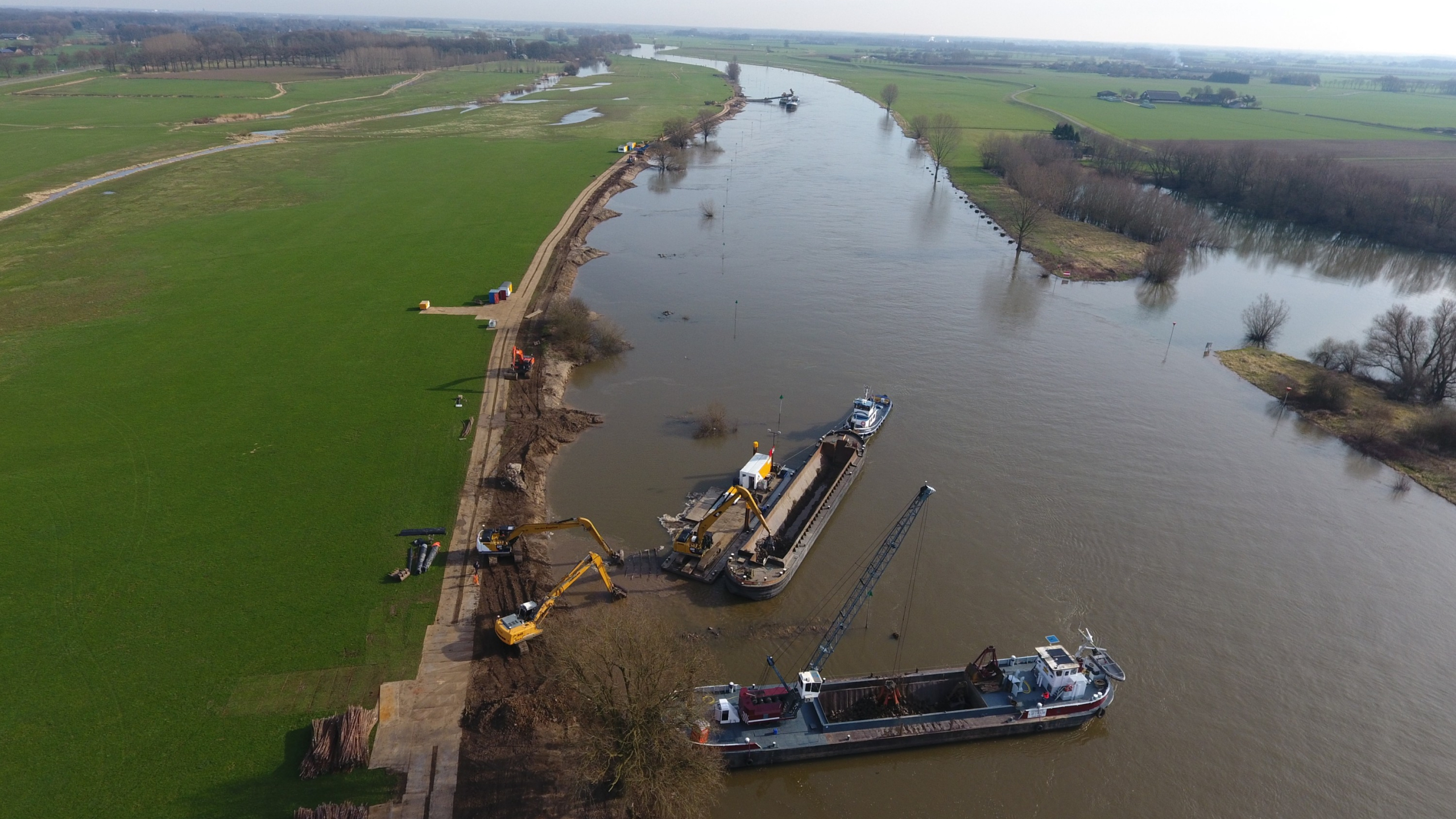 Luchtfoto van werkschepen en kranen aan het werk naast de IJssel 