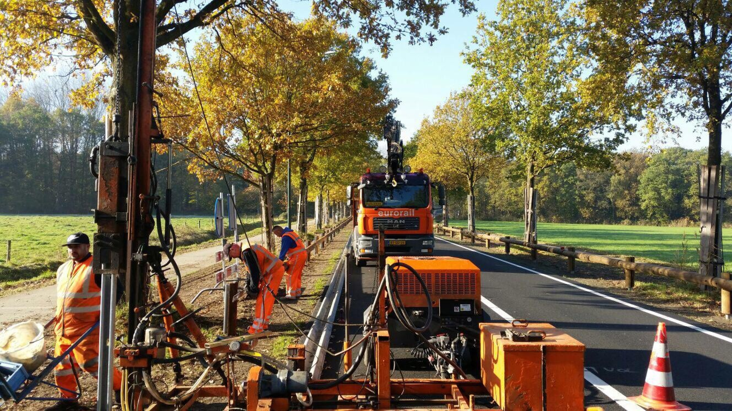 Oranje vrachtwagen en machines aan het werk op de N618 tussen Boxtel en Schijndel