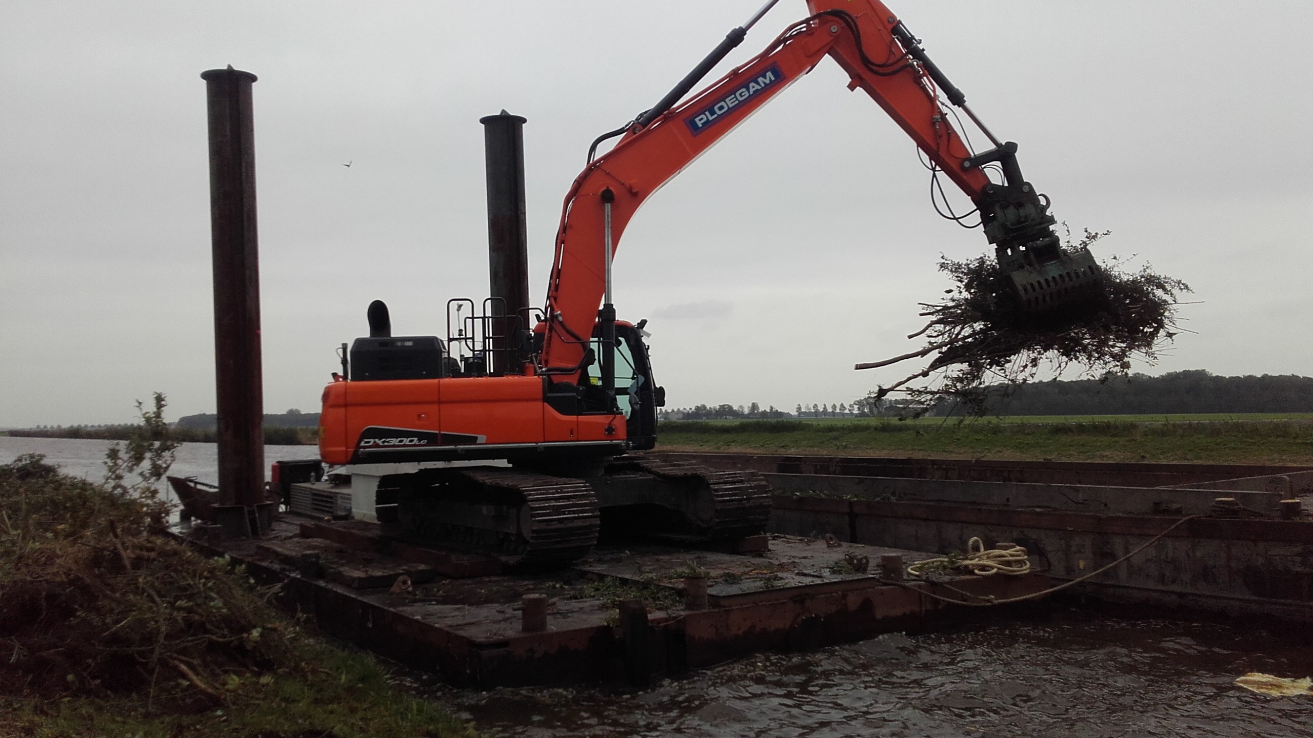 Oranje kraan werkt vanaf ponton op het water