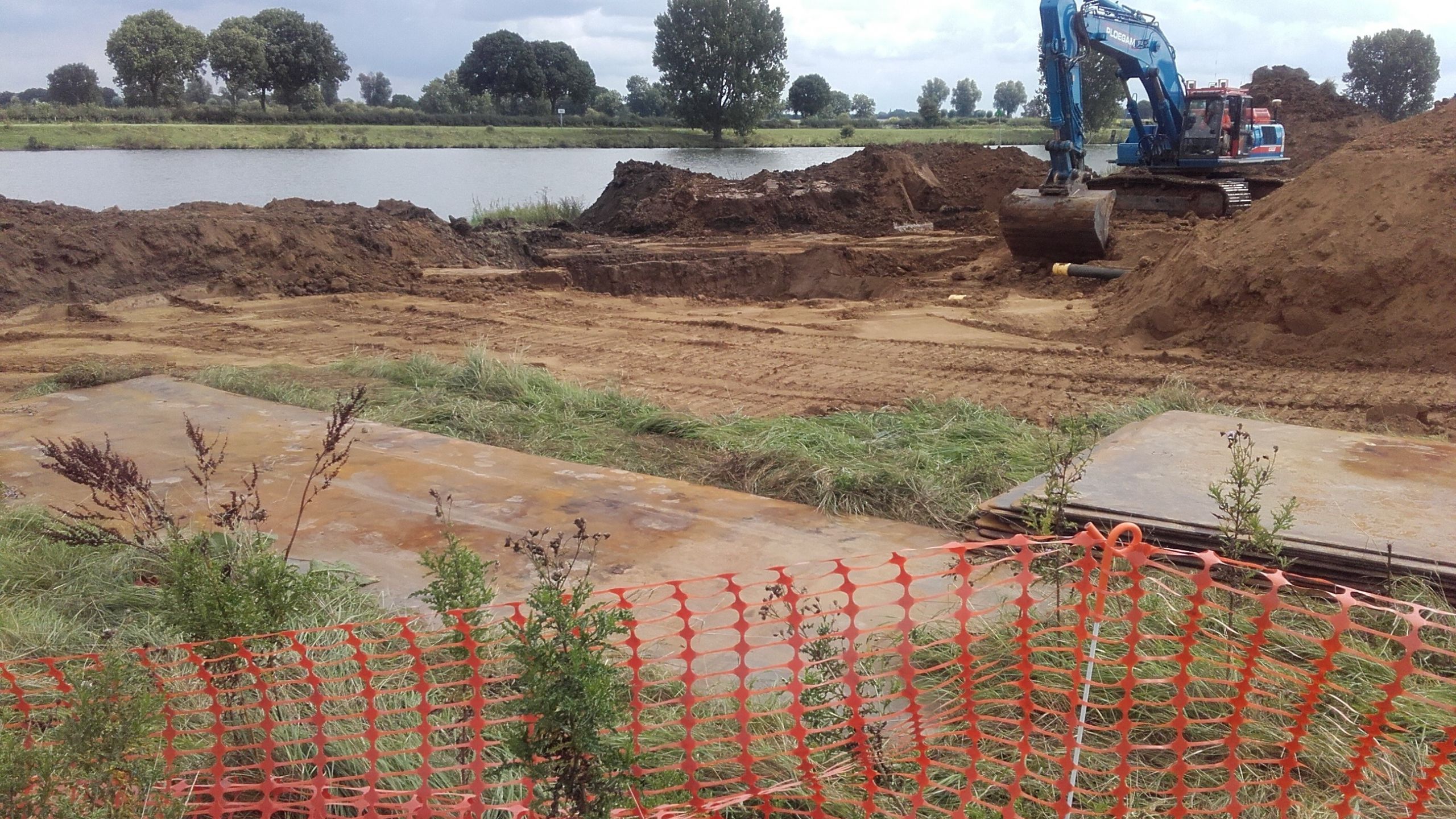 Blauwe Ploegam kraan in het zand met rivier op de achtergrond