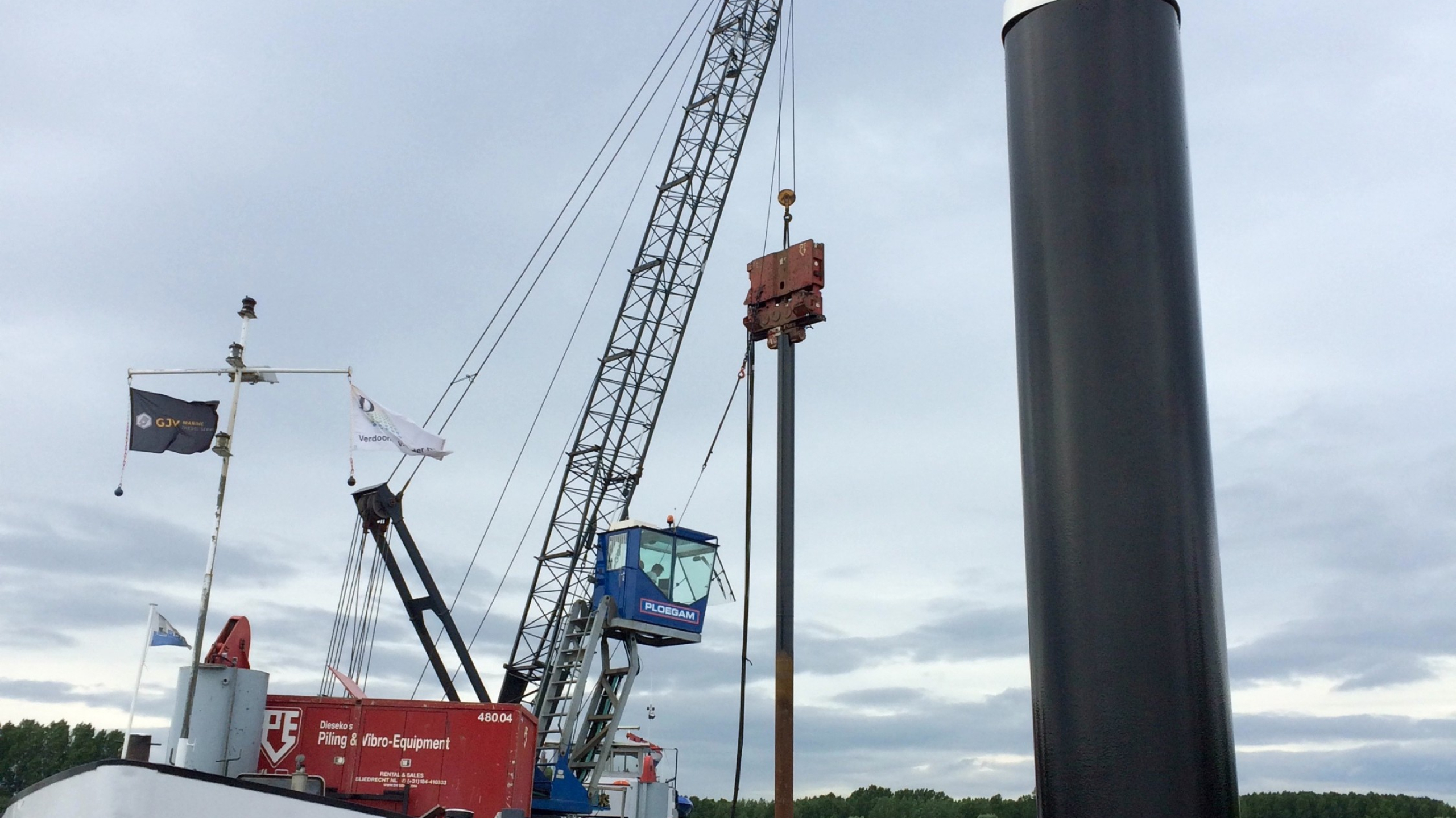 Ploegam kraan plaatst damwanden vanaf een schip