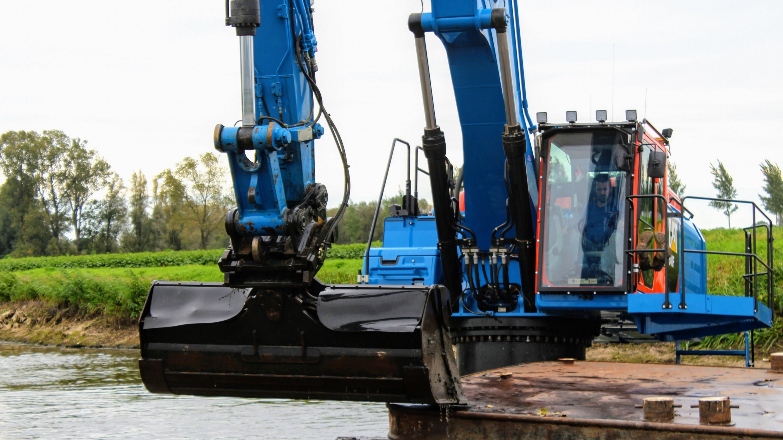 Blauwe Ploegam kraan op het water aan het baggeren