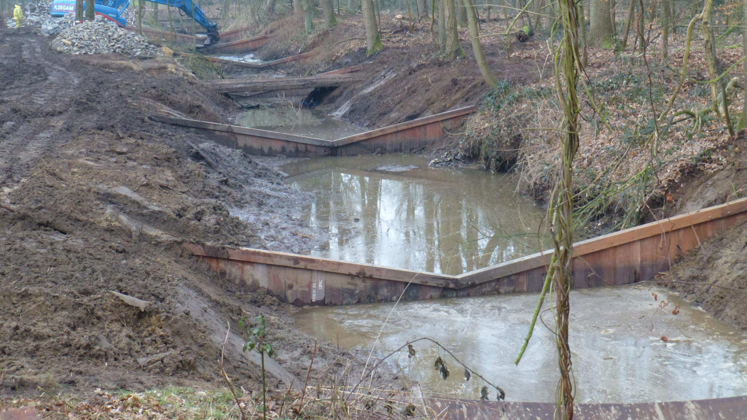 Houten damwanden in de Vispassage van Elisabethmolen met blauwe kraan op de achtergrond