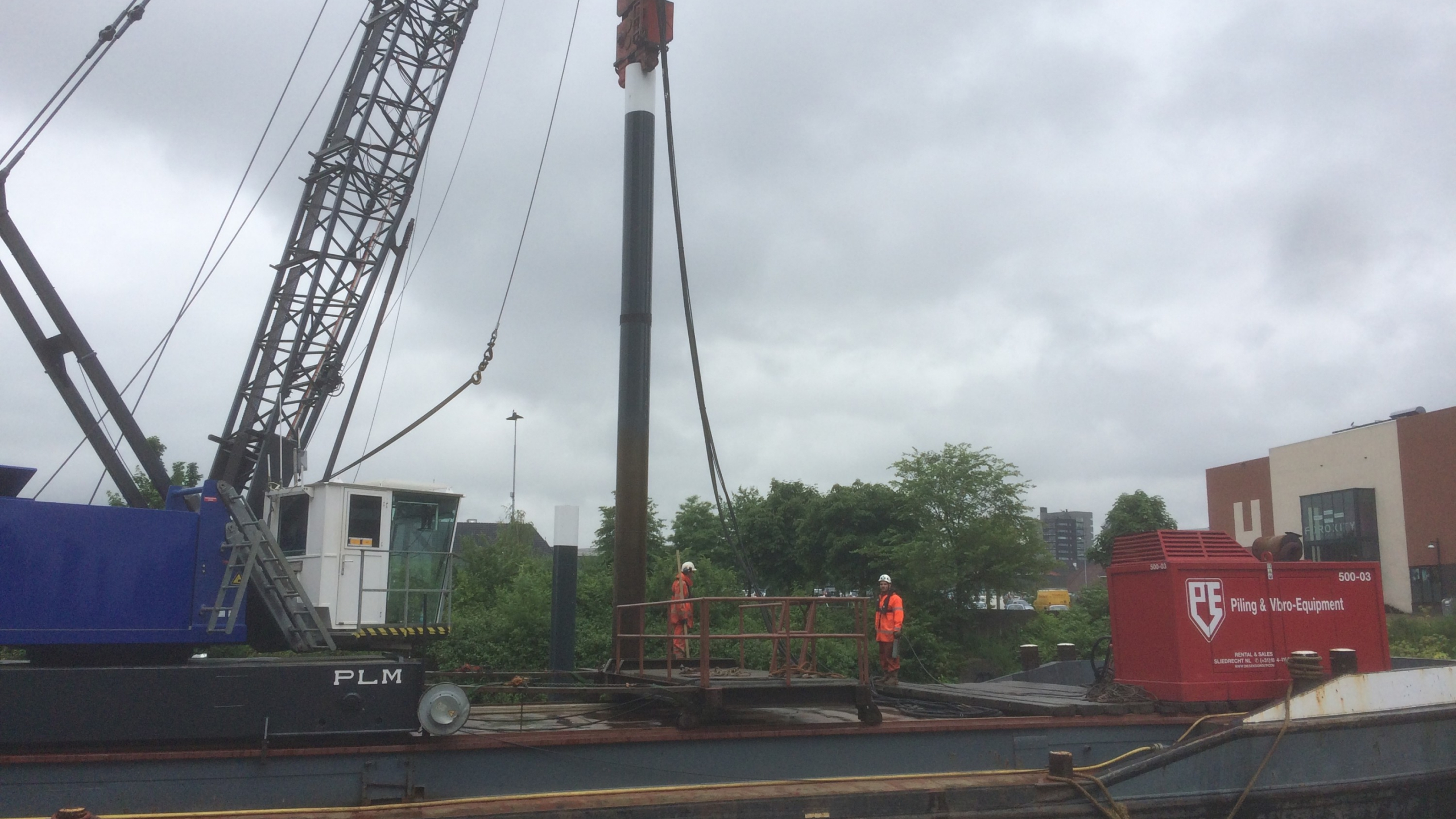 Boot met medewerkers in oranje veiligheidskleding in de Maashaven Roermond