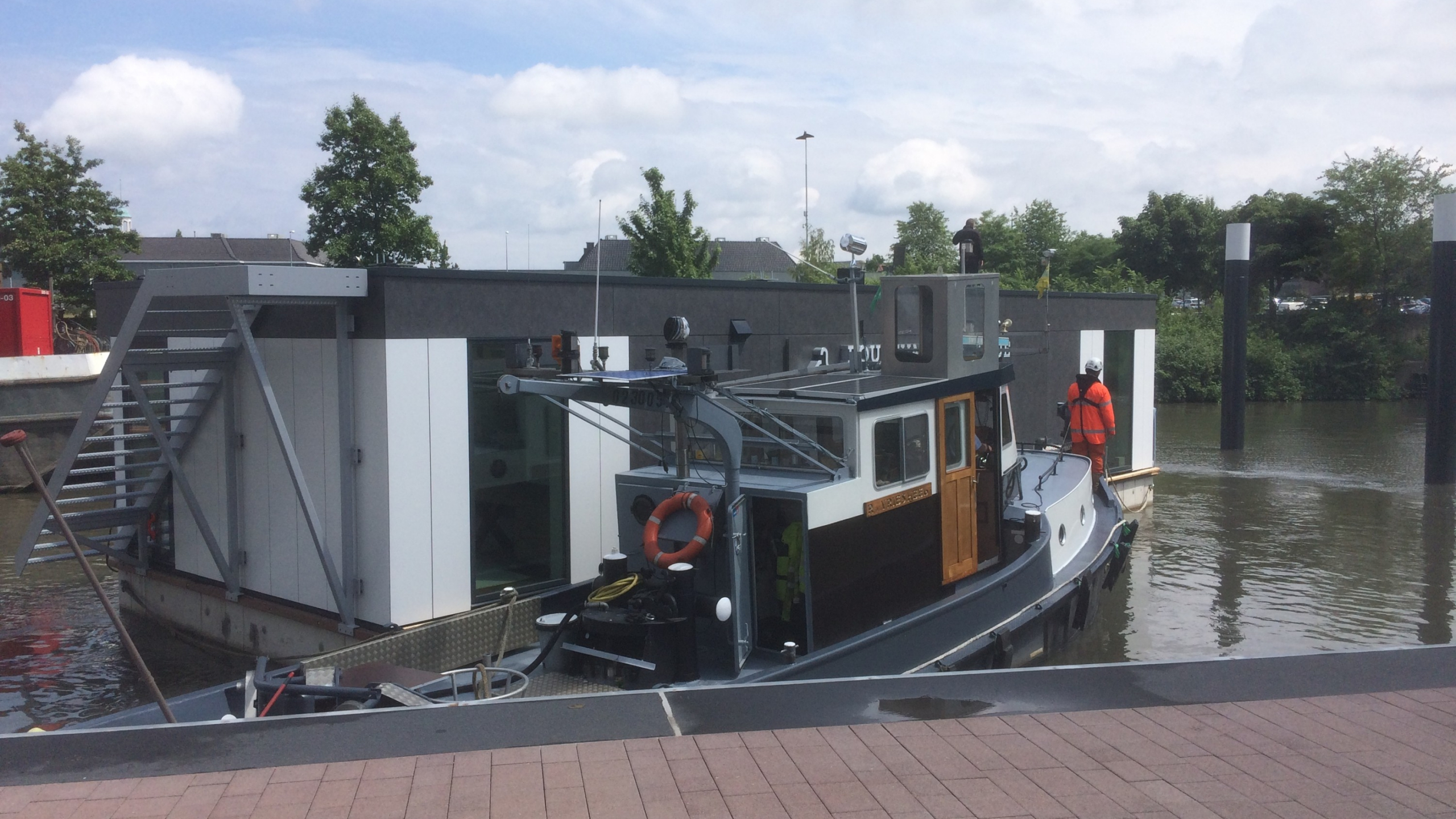 Boot met persoon in oranje veiligheidskleding tijdens werkzaamheden Maashaven Roermond