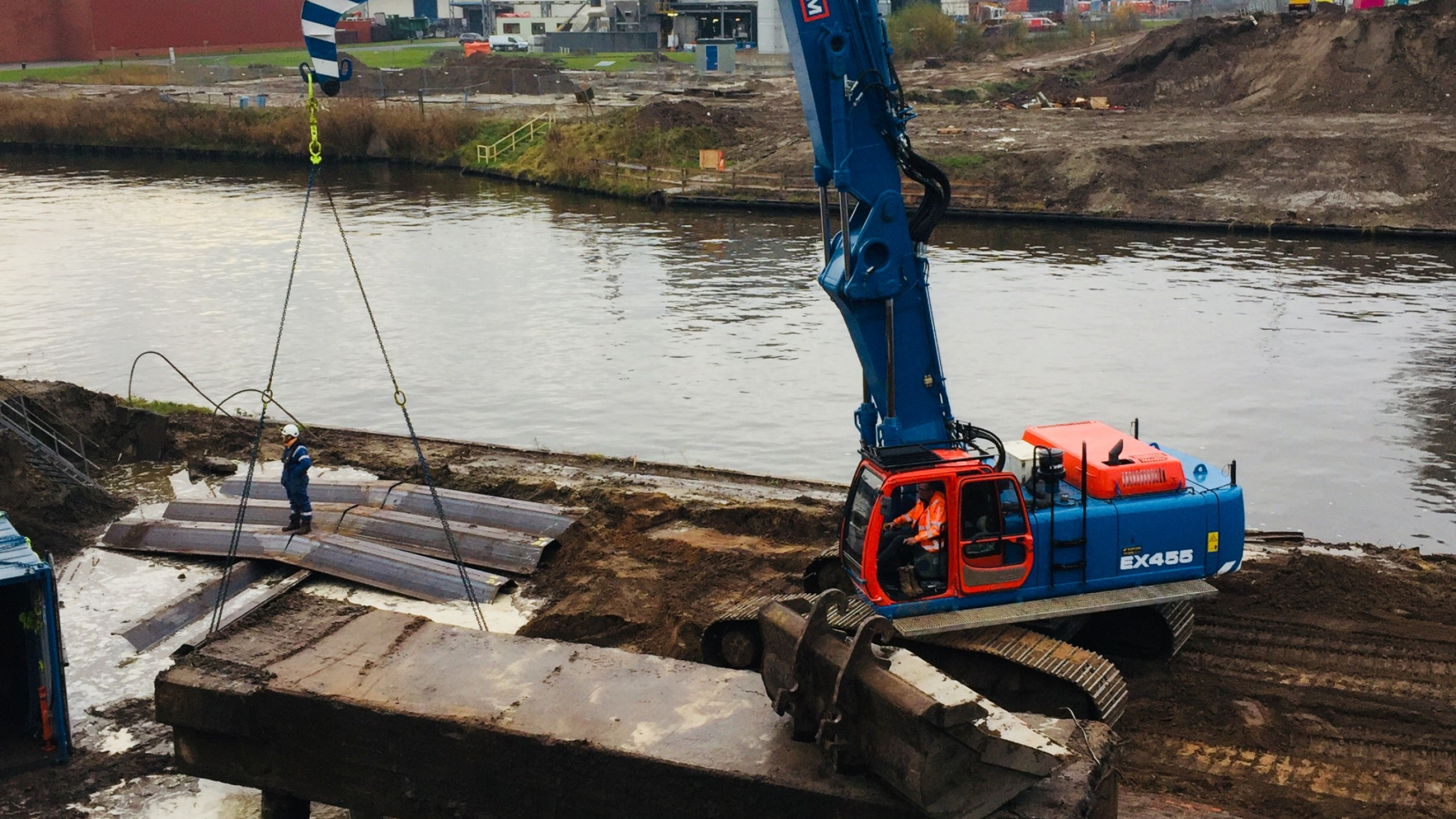 Blauwe kraan op het zand naast het water in Hengelo