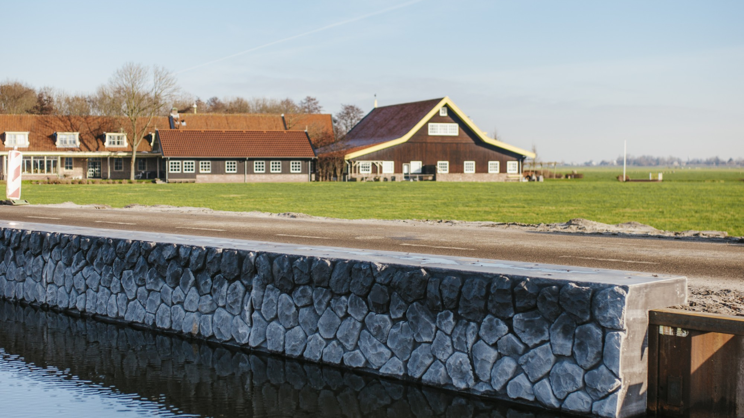 Kade van stenen met huizen op de achtergrond in de Boterhuispolder