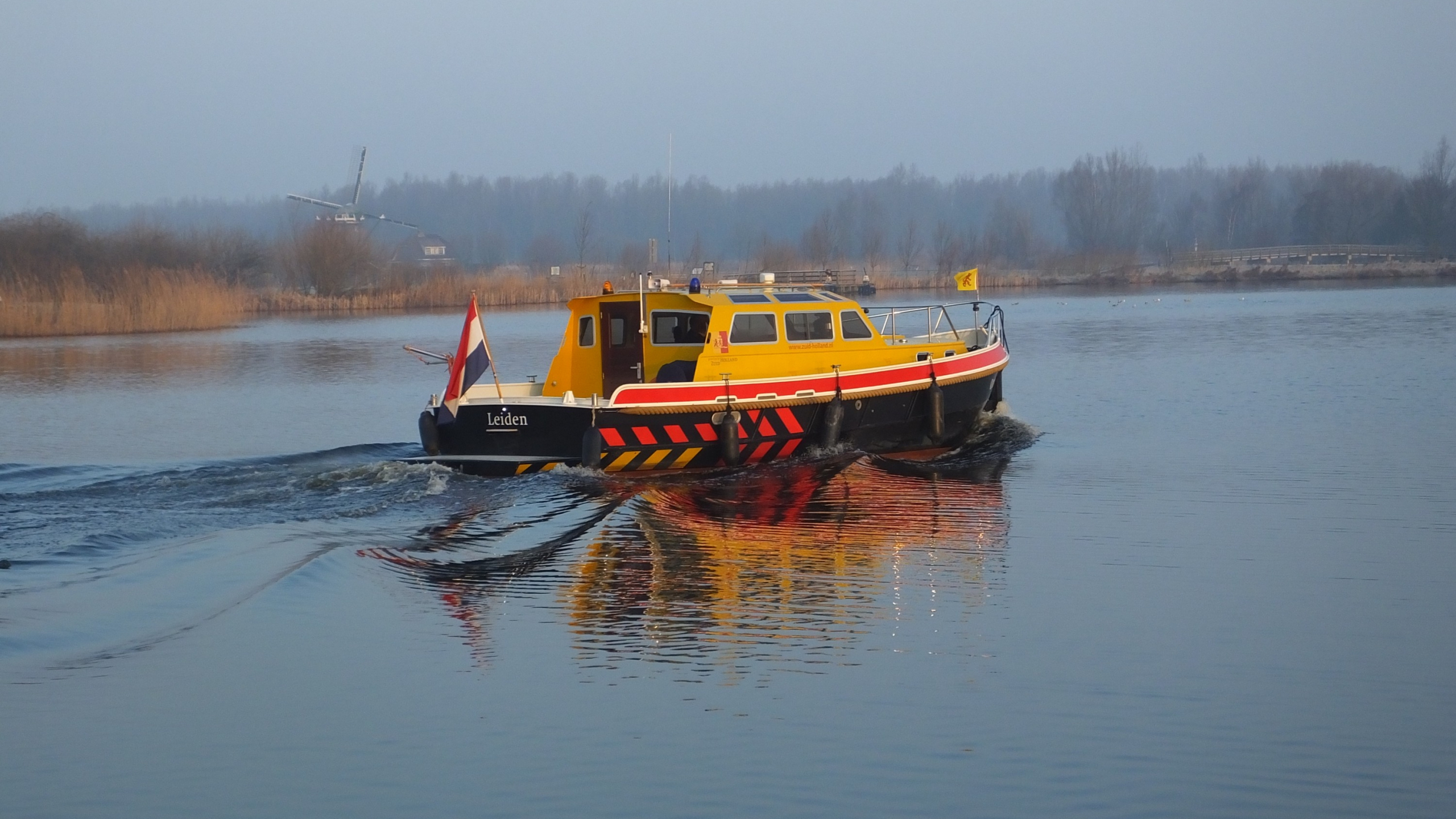 Geel-zwarte boot vaart in het water in de Boterhuispolder