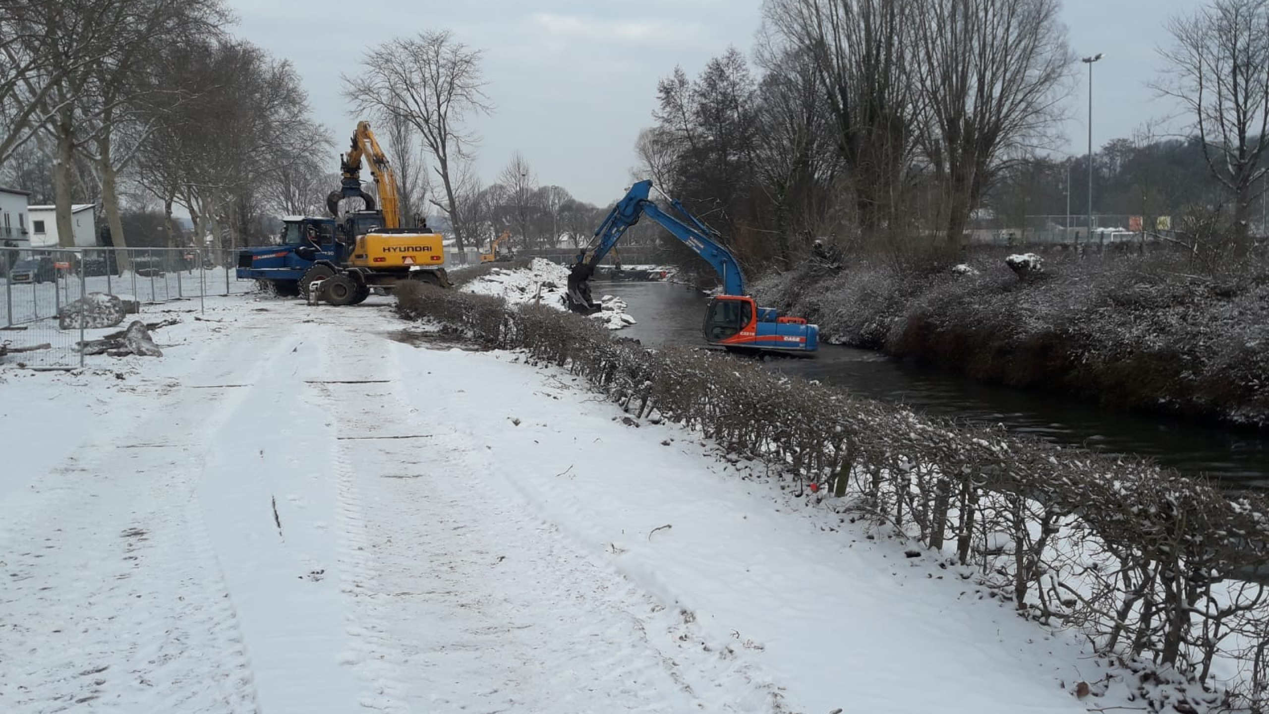 Kranen werken bij beek in de sneeuw