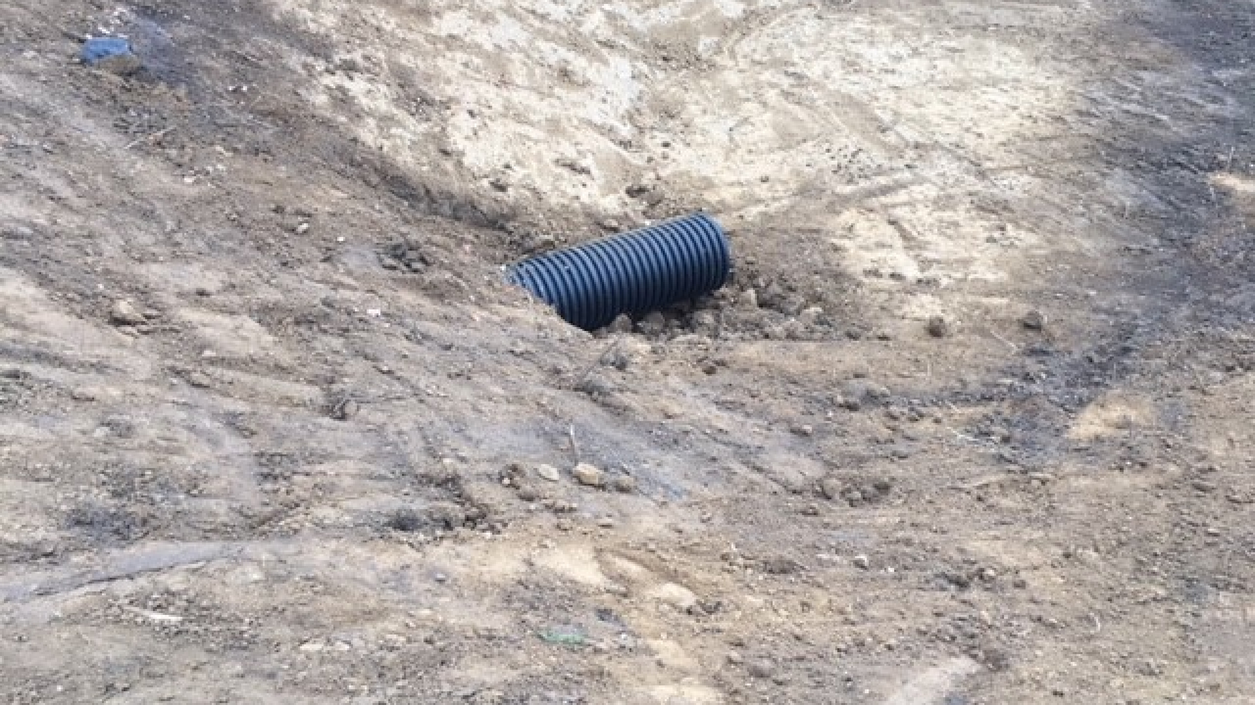 Zwarte buis steekt uit het zand