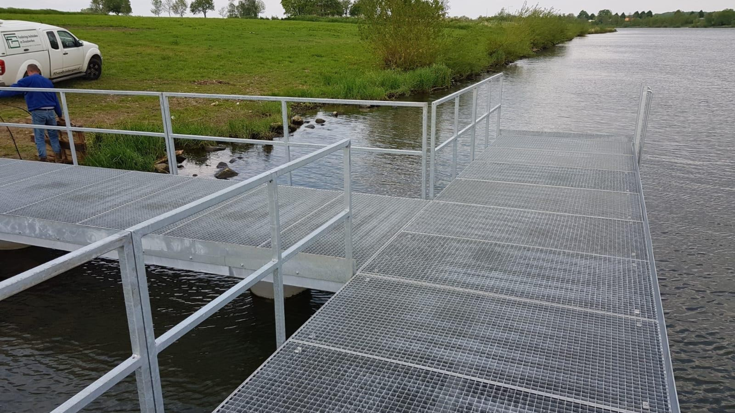 T-stijger op het water van de Maas met een witte bus op de achtergrond
