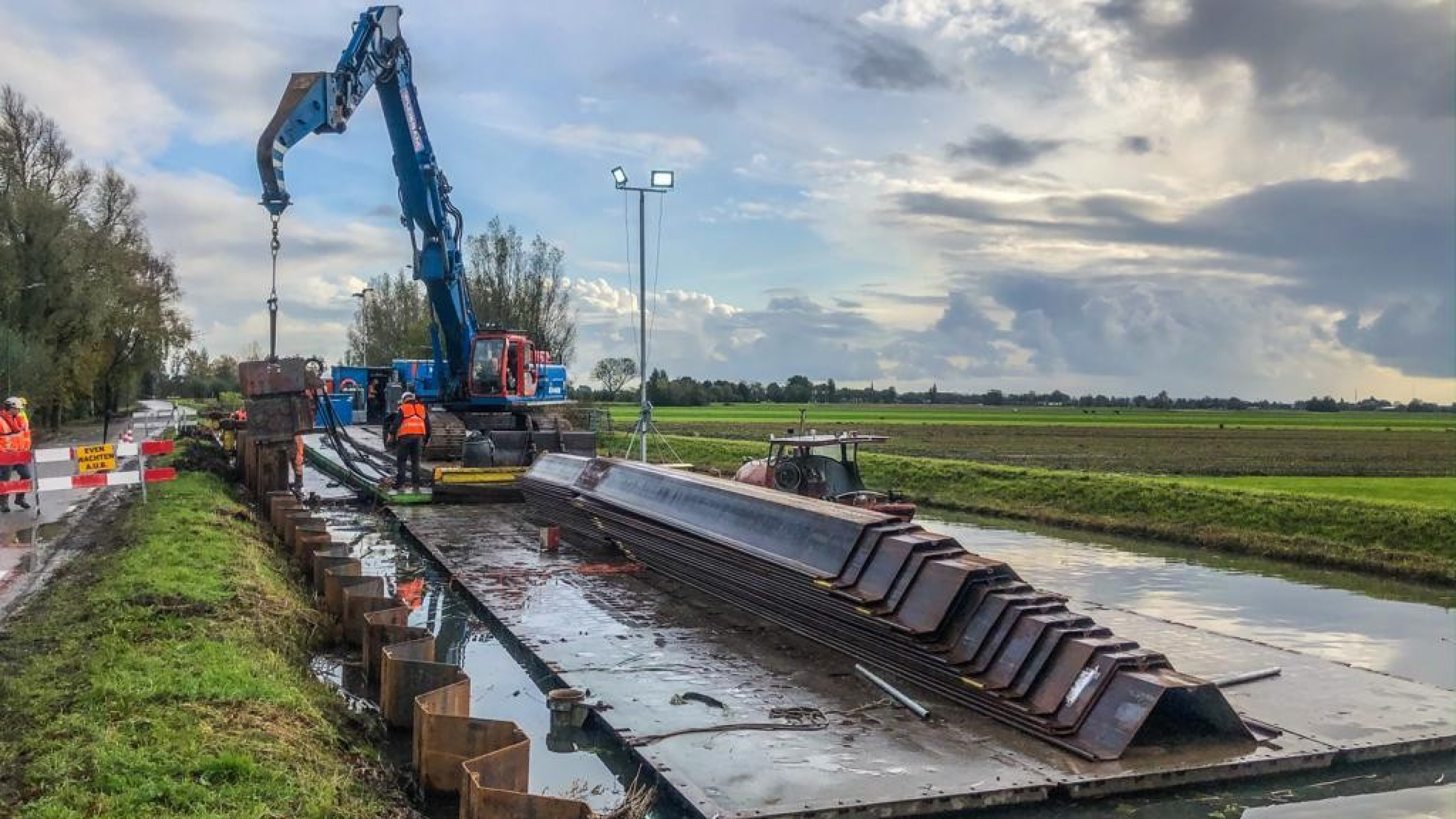 Blauwe Ploegam kraan aan het werk vanaf ponton op het water in de Montfoortsevaartkade