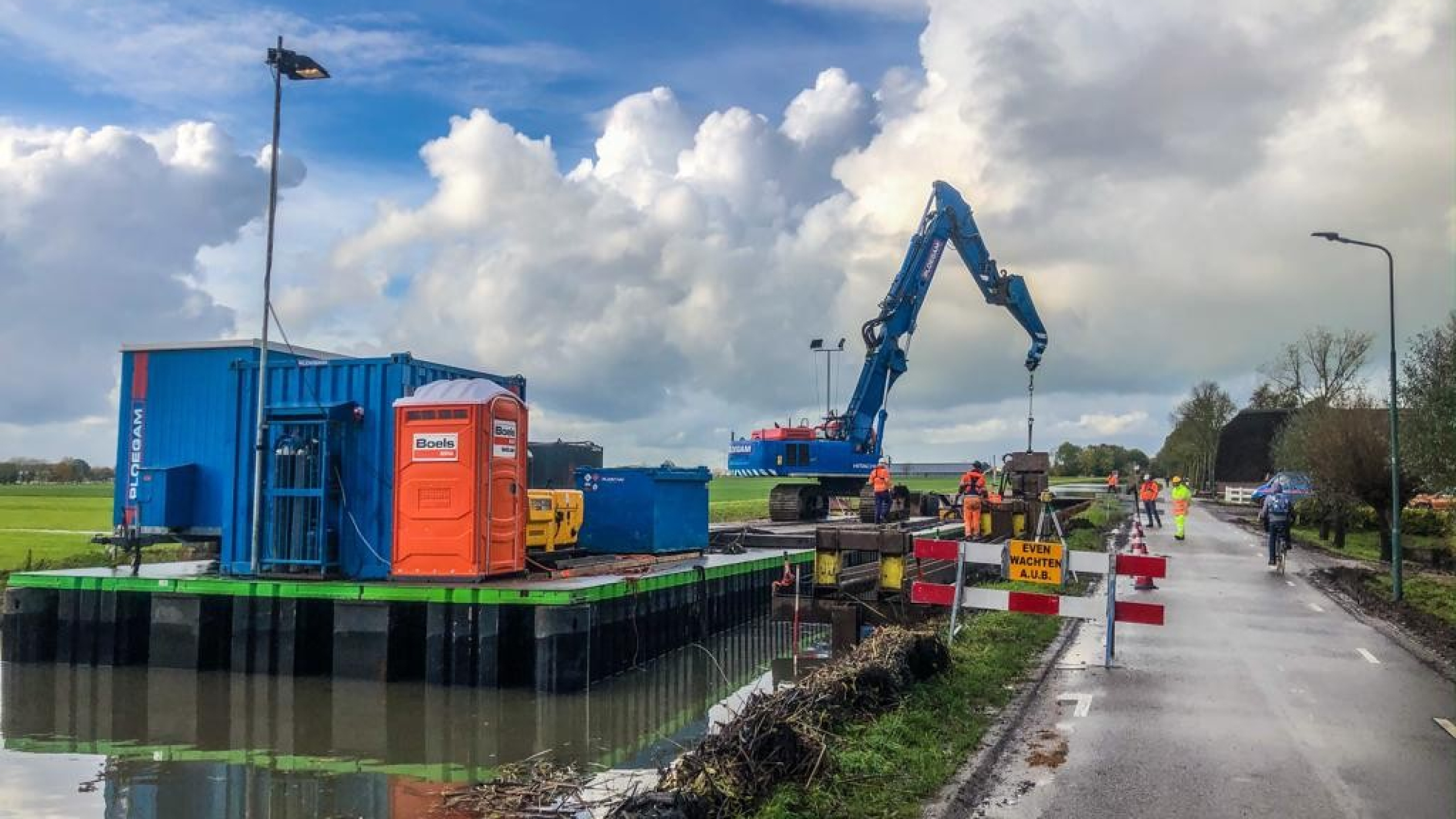 Blauwe Ploegam kraan aan het werk vanaf ponton op het water in de Montfoortsevaartkade