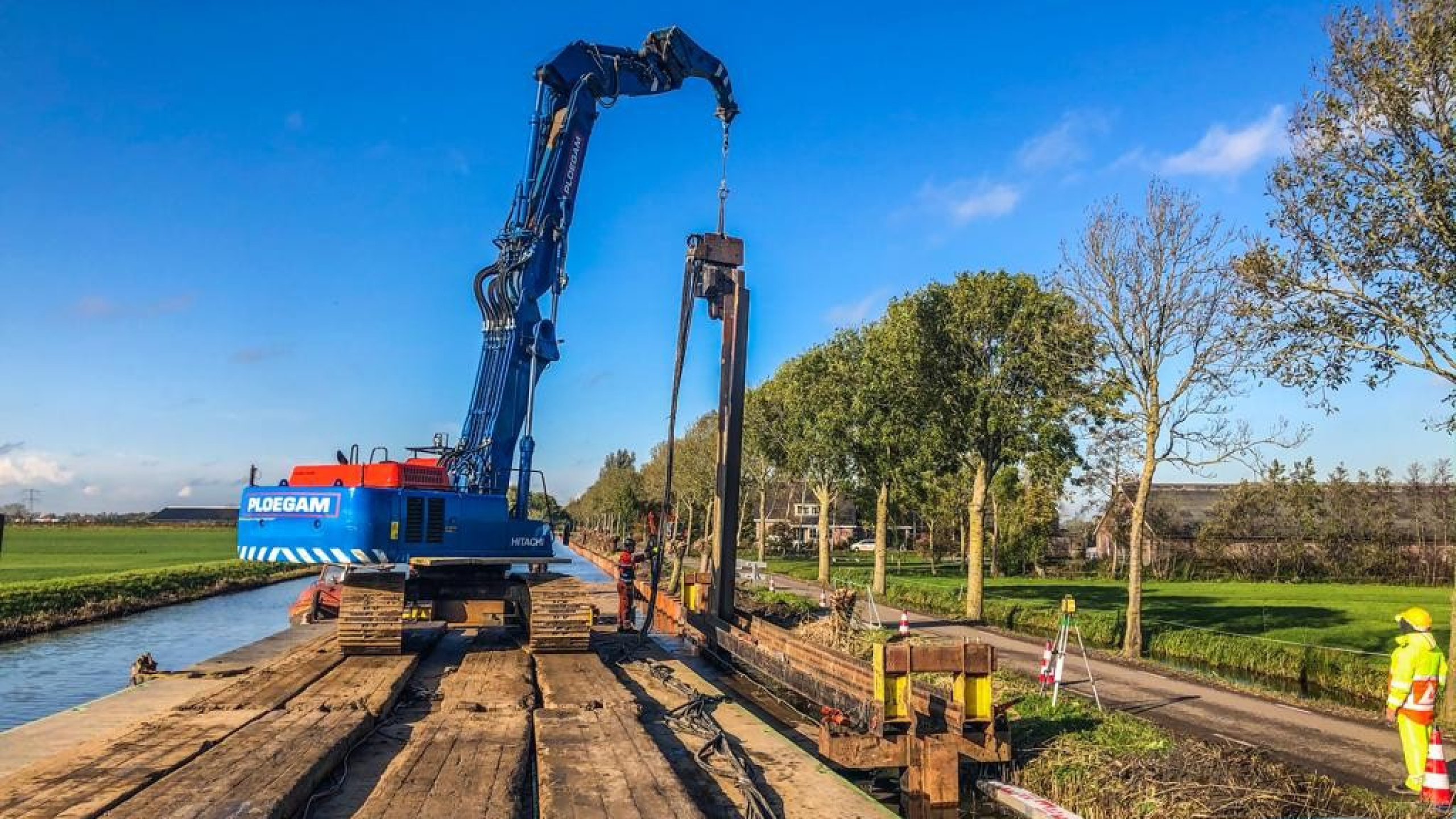 Blauwe Ploegam kraan aan het werk vanaf ponton op het water in de Montfoortsevaartkade