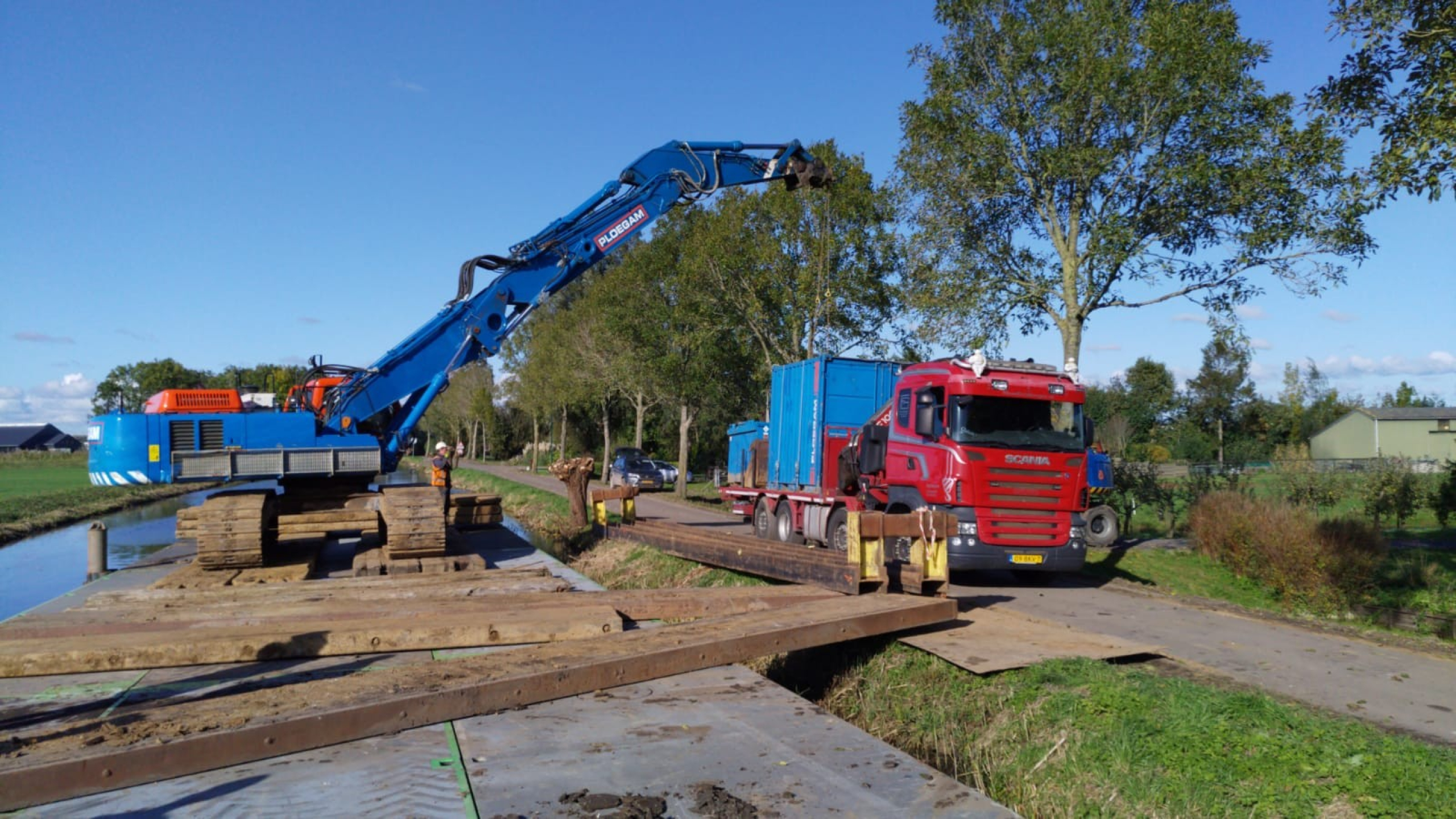 Blauwe Ploegam kraan aan het werk vanaf ponton op het water in de Montfoortsevaartkade