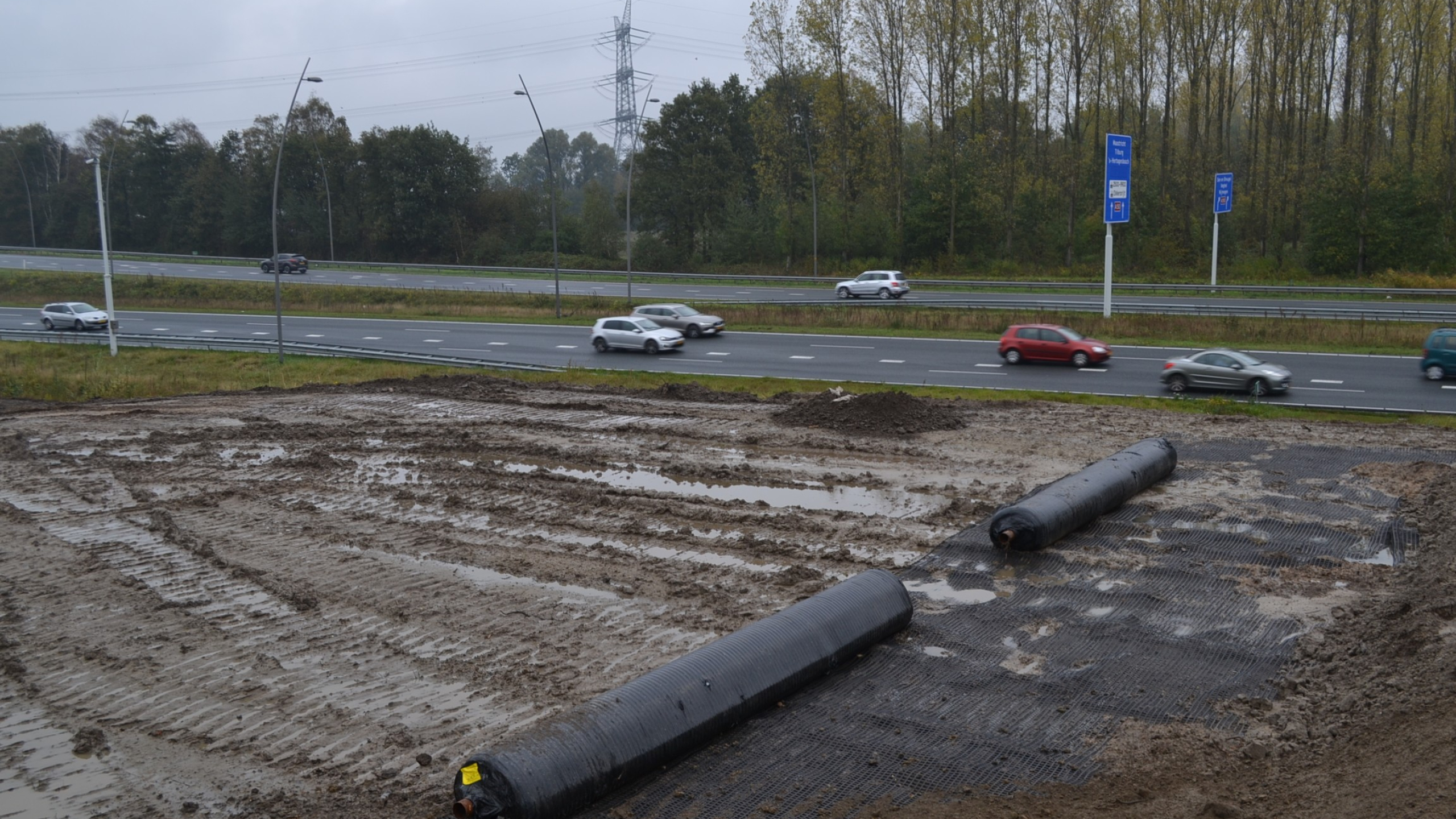 Grondwerk bouwplaats direct naast een snelweg met auto's