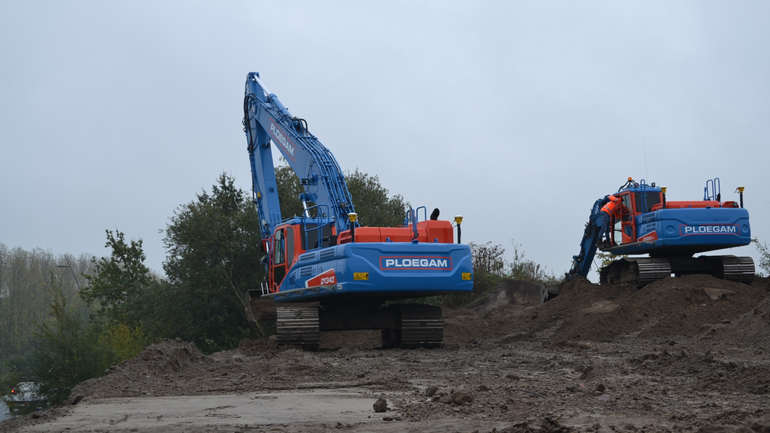 Twee Ploegam kranen naast elkaar aan het werk in het zwarte zand