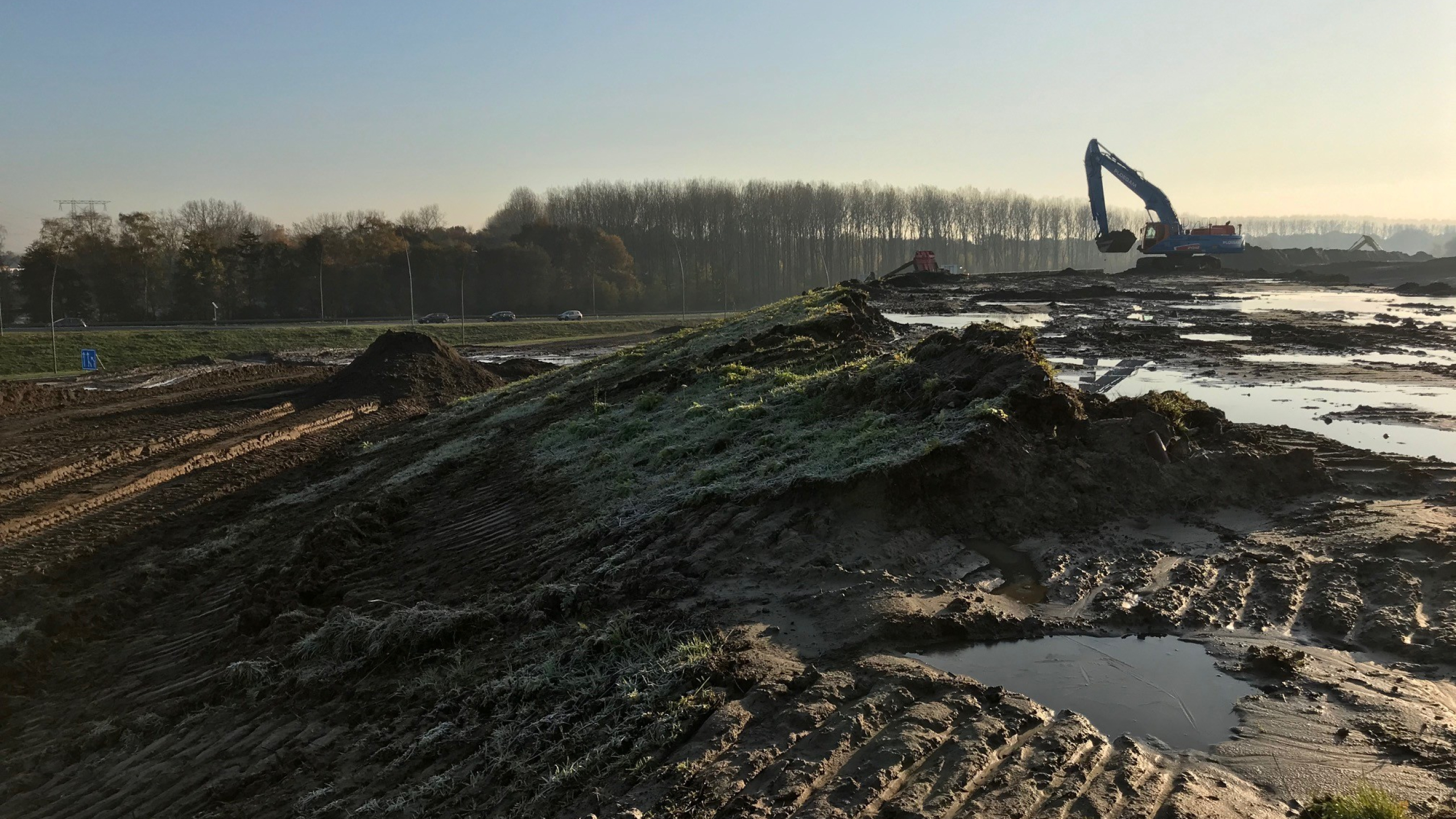 Blauwe Ploegam kraan aan het werk in het zand op een bouwplaats