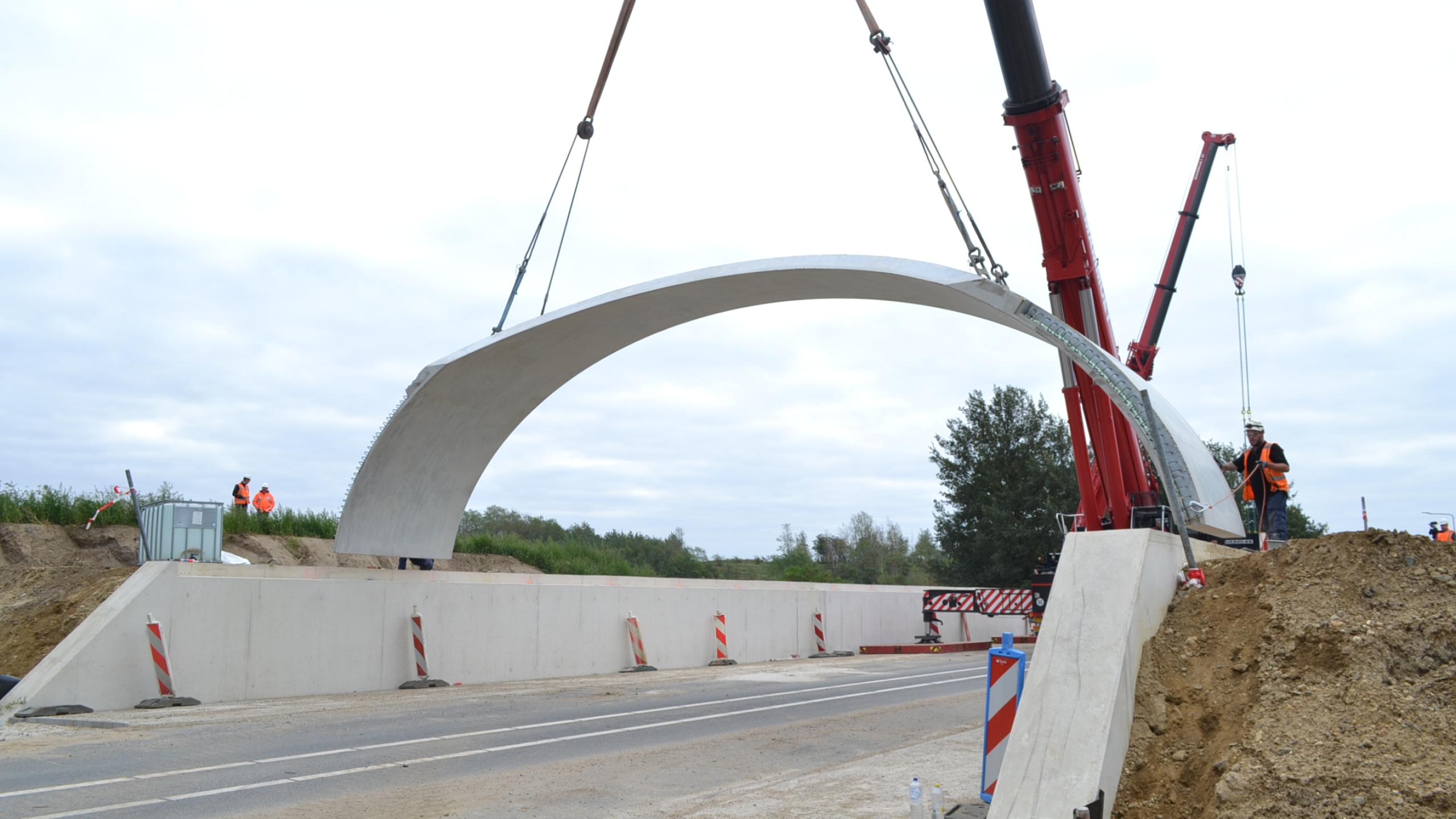 Rode kraan plaatst betonnen koepel bij ecoduct