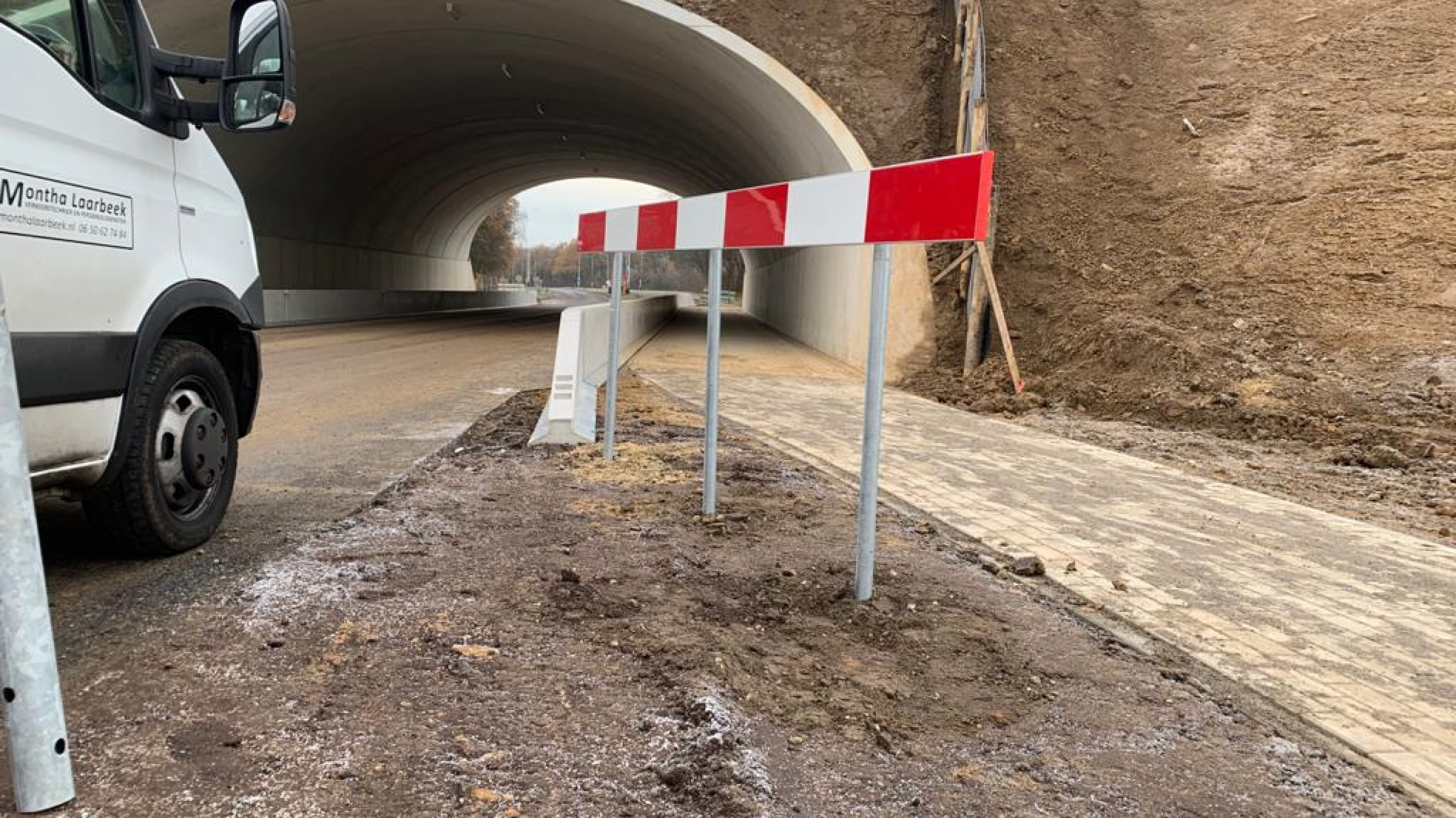 Rood-wit verkeersbord met witte bus voor een viaduct