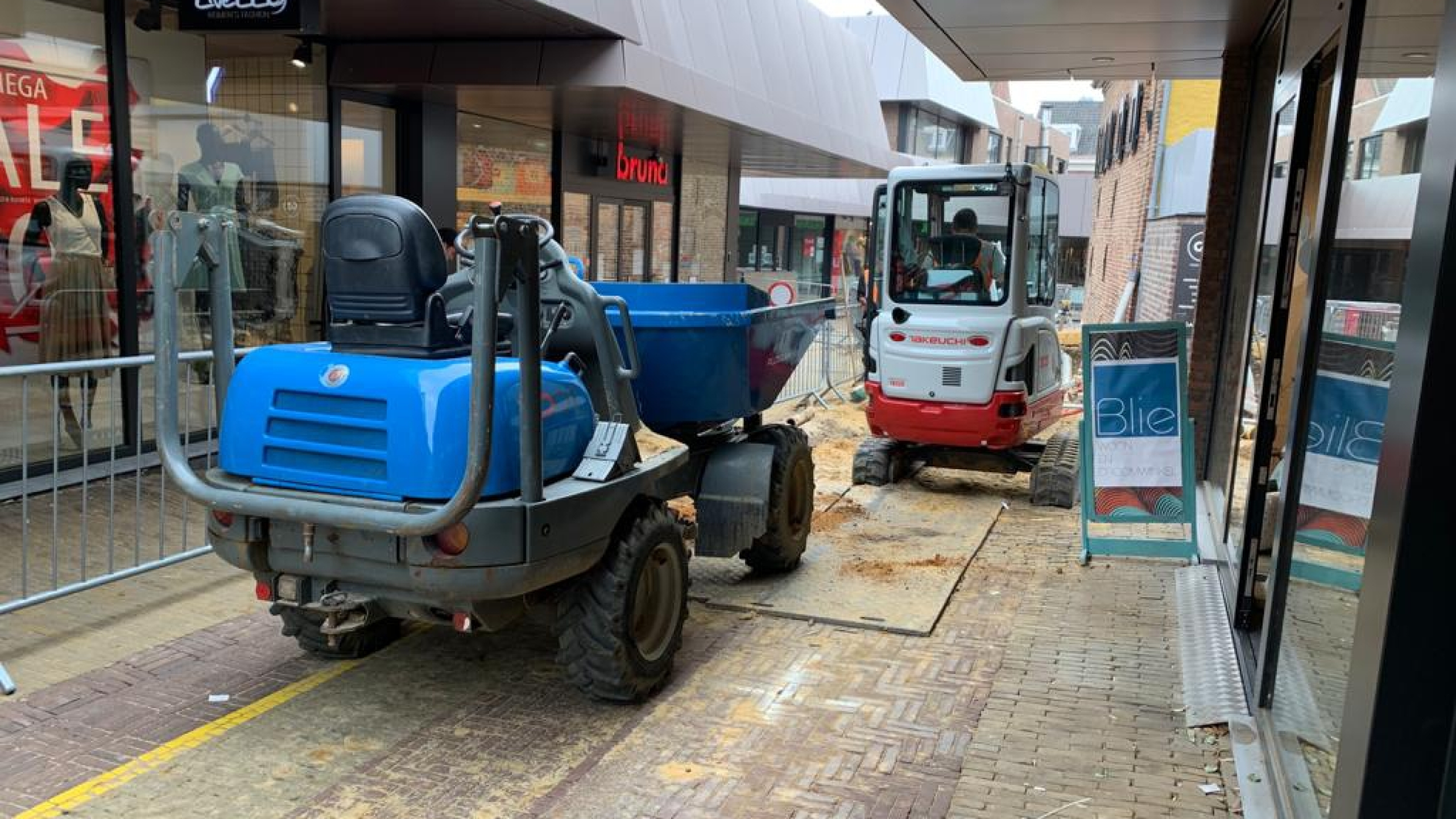 Graafmachine en blauwe machine aan het werk in winkelstraat Sittard