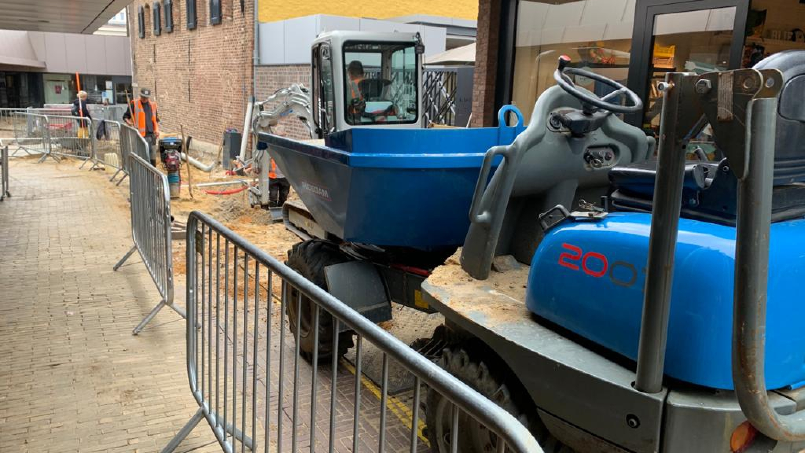 Bouwvakkers aan het werk in winkelstraat Sittard, werkgebied afgesloten met bouwhekken