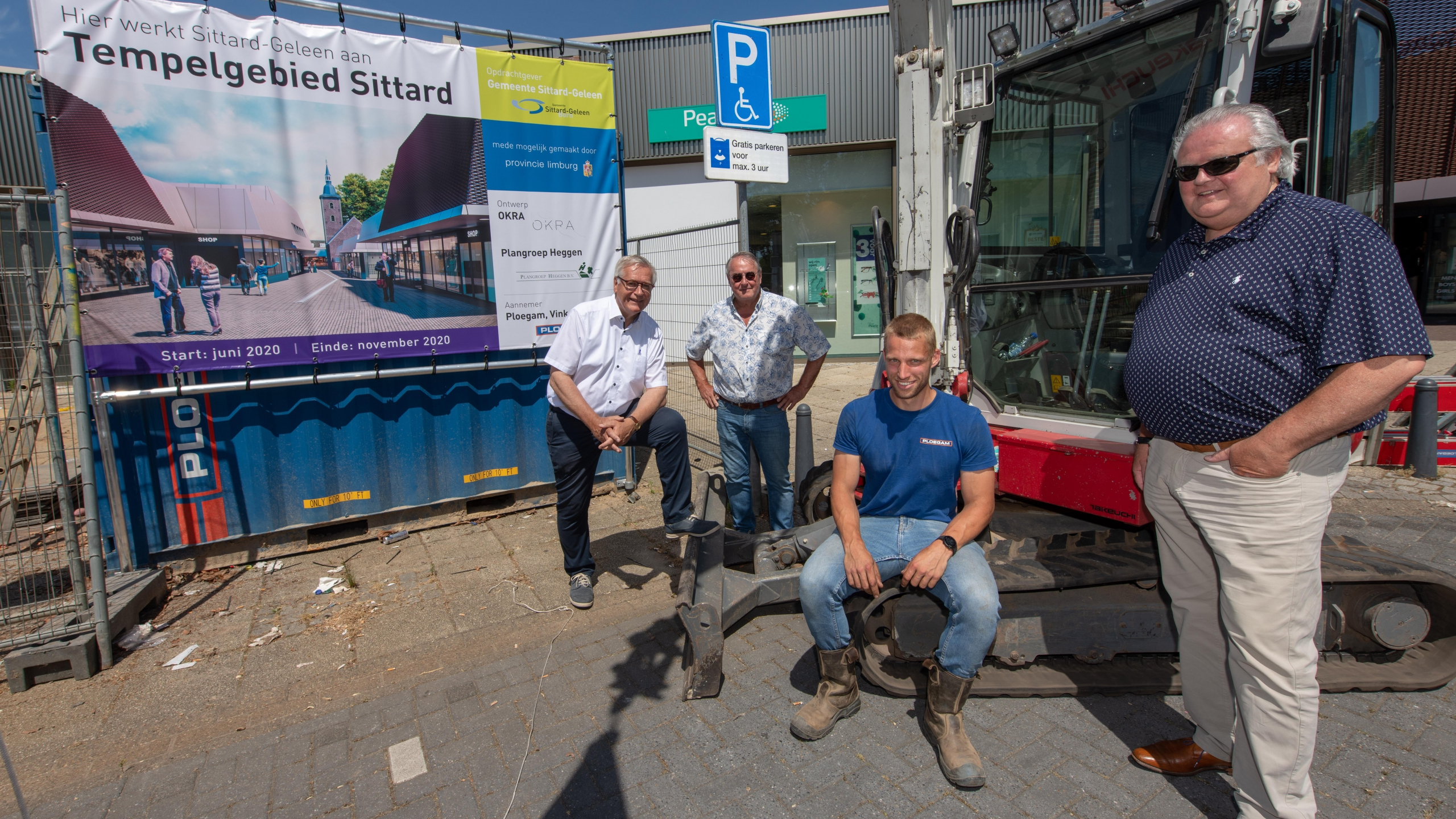Vier mannen staan naast graafmachine en informatiedoek van het project Tempelgebied Sittard