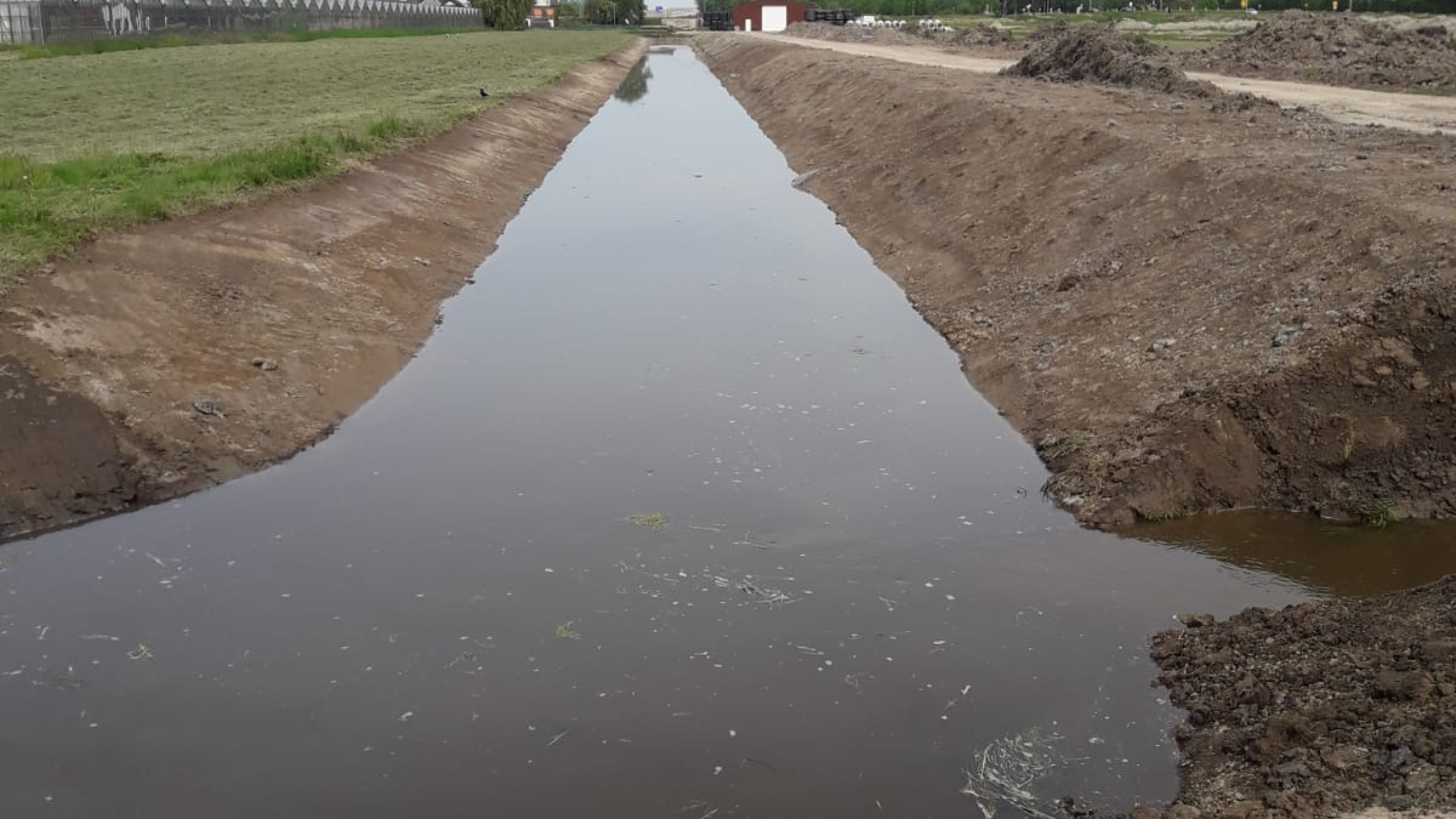 Beekje water tussen twee bulten van zand en gras