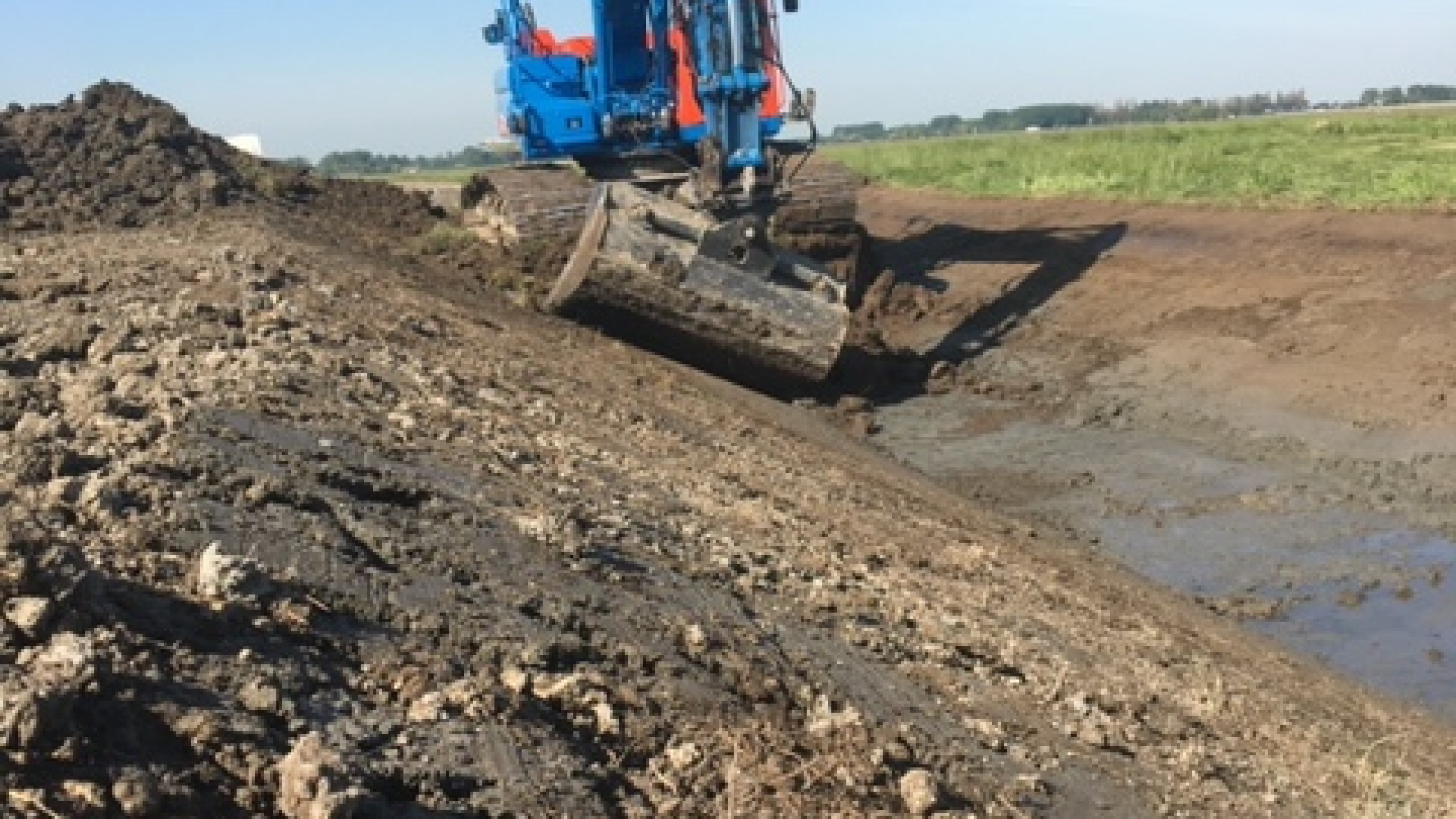 Blauwe Ploegam kraan schept zand op project Polder Schieveen Zuid en Schiebroeksepolder