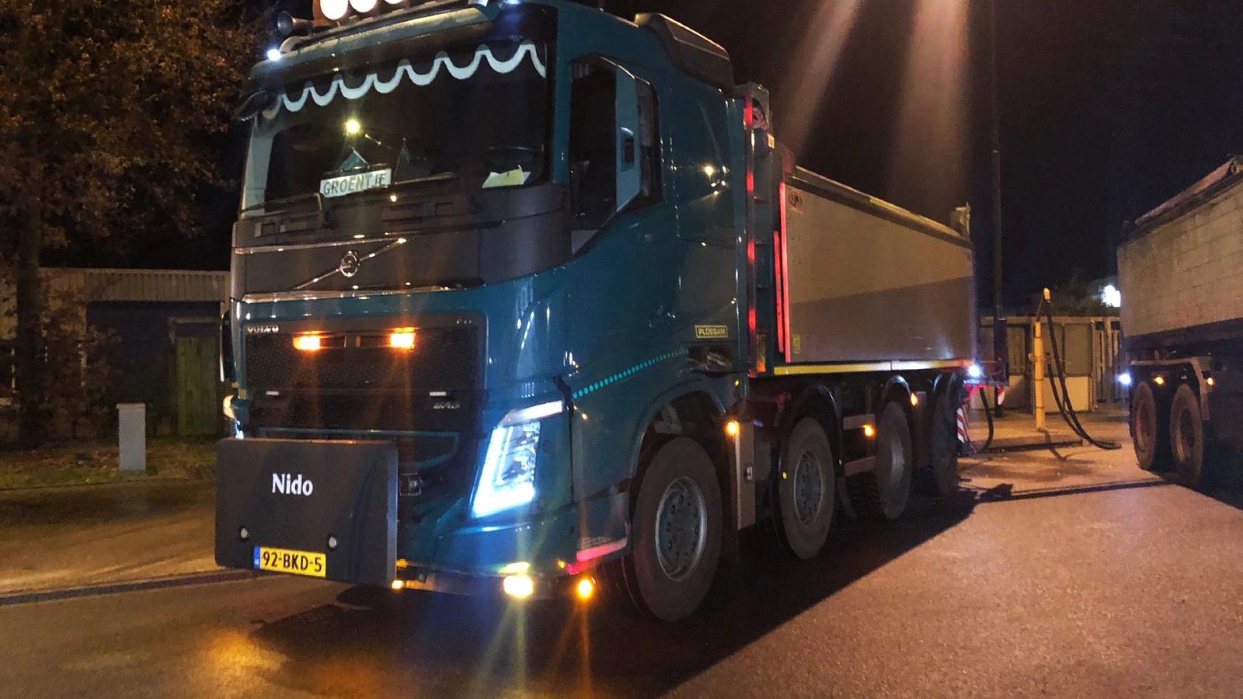 Blauwe Ploegam gladheidsbestrijding vrachtwagen in het donker