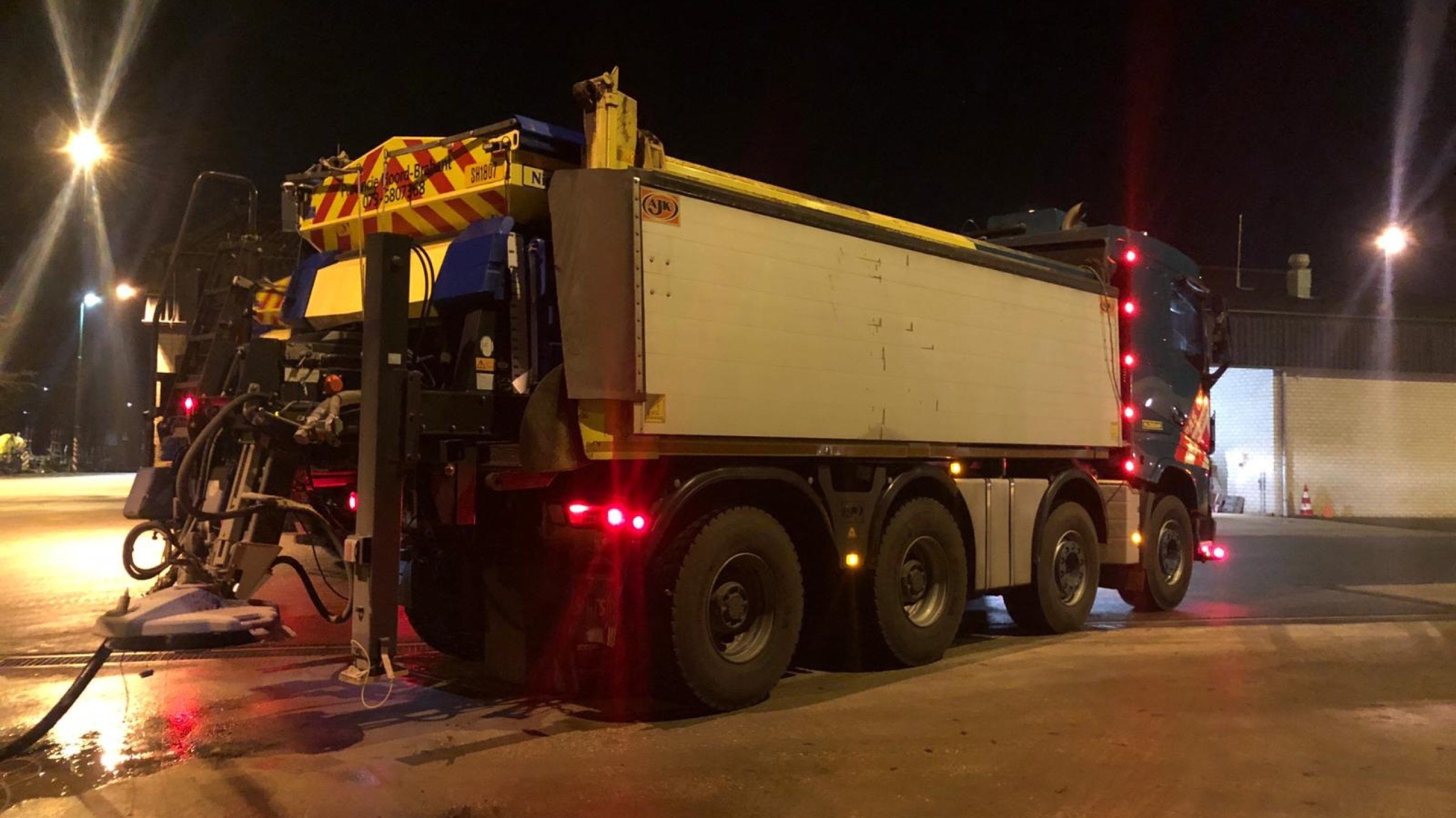 Blauwe Ploegam gladheidsbestrijding vrachtwagen gaat strooien in het donker