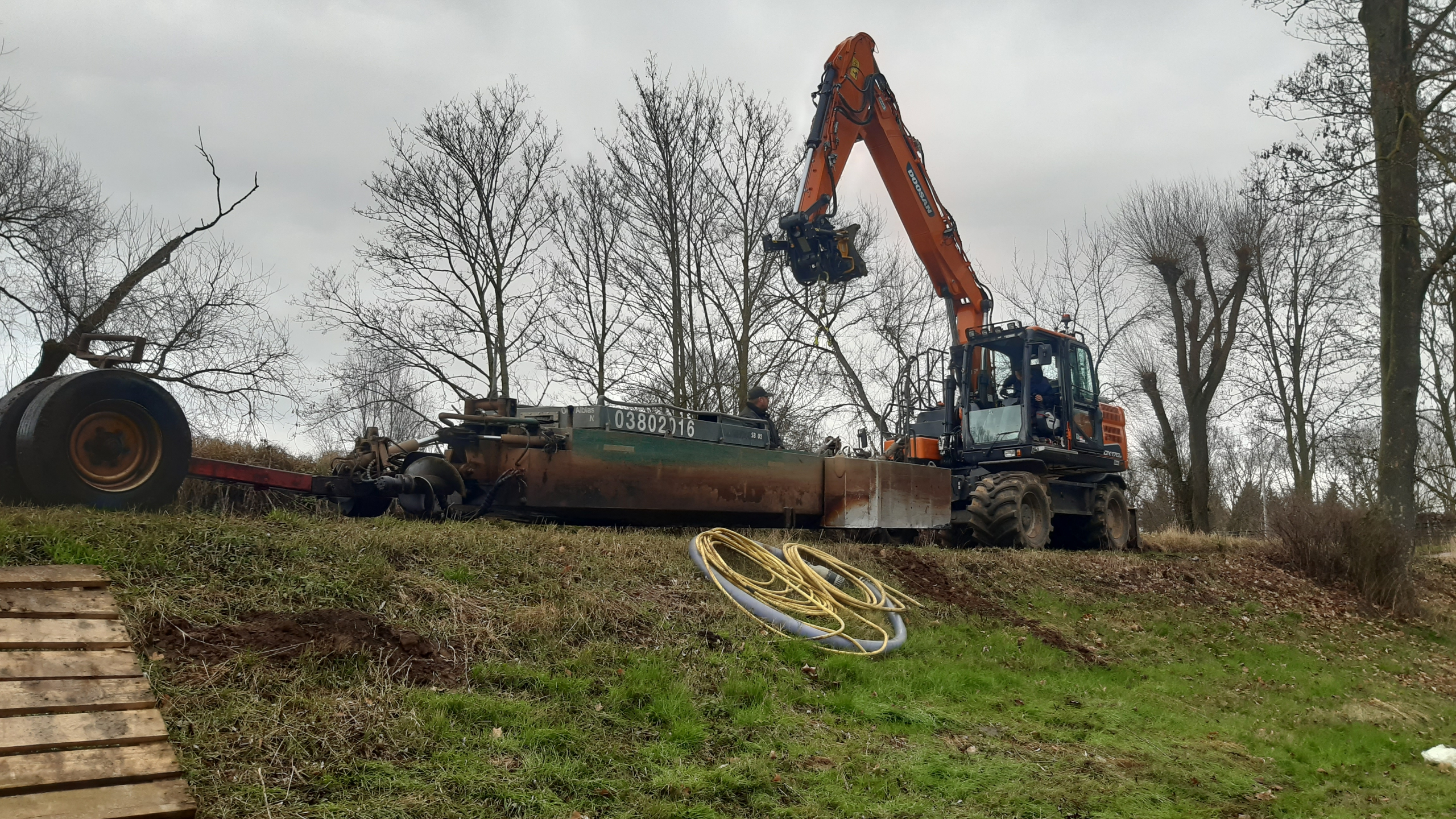 Oranje kraan op heuvel met bomen op de achtergrond