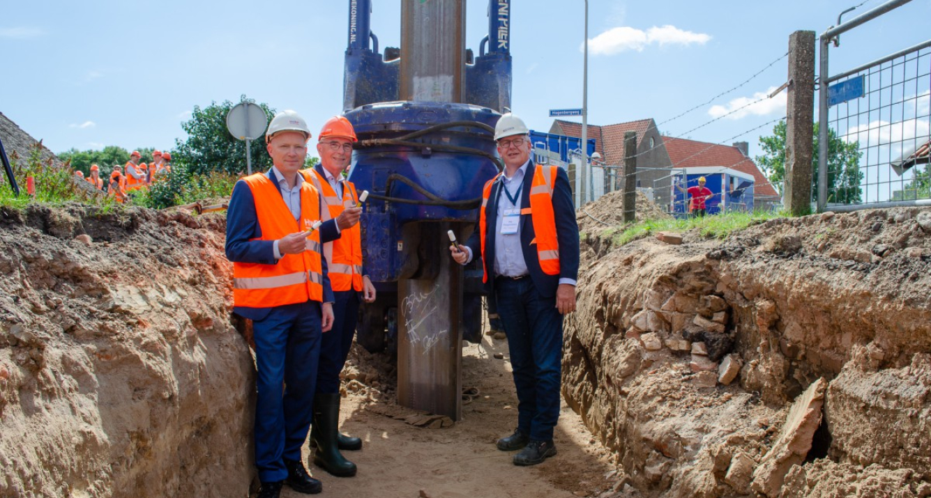 Breun Breunissen, Eric Withaar en Gijs Ploegmakers (namens Dijkzone Alliantie Stenendijk) zetten hun  handtekening op een 12 meter lange damwand die wordt gebruikt voor het versterken van de Stenendijk in Hasselt. 