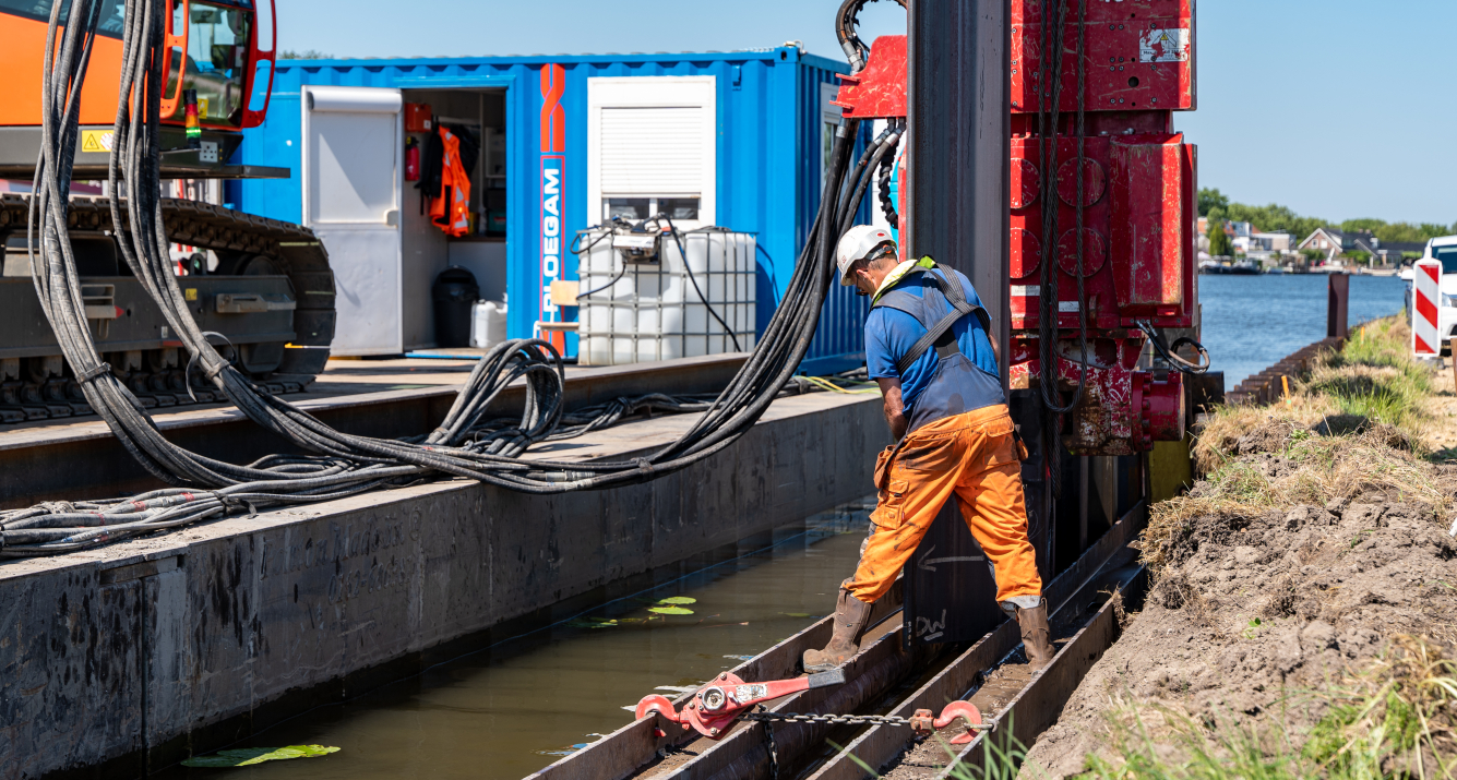 Ploegam medewerker is damwanden aan het plaatsen bij een rivier