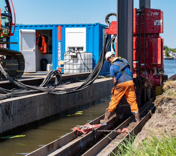 Ploegam medewerker is damwanden aan het plaatsen bij een rivier
