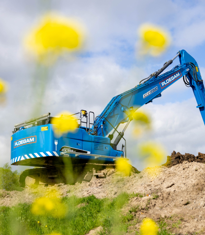 Man met oranje veiligheidshesje in blauwe kraan naast het water