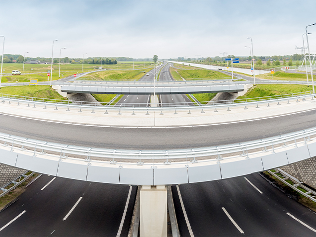 Viaduct over weg met lantaarnpalenen een groene berm