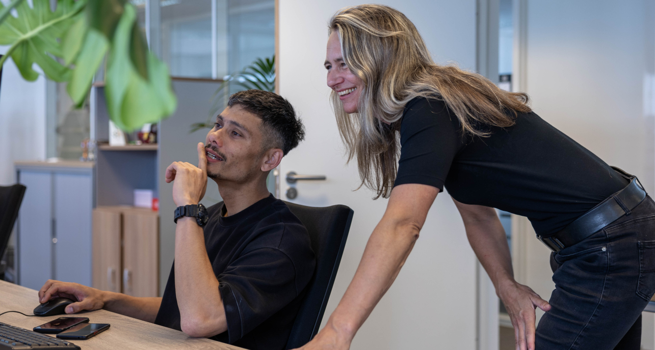 Twee collega's op kantoor samenwerken achter computer